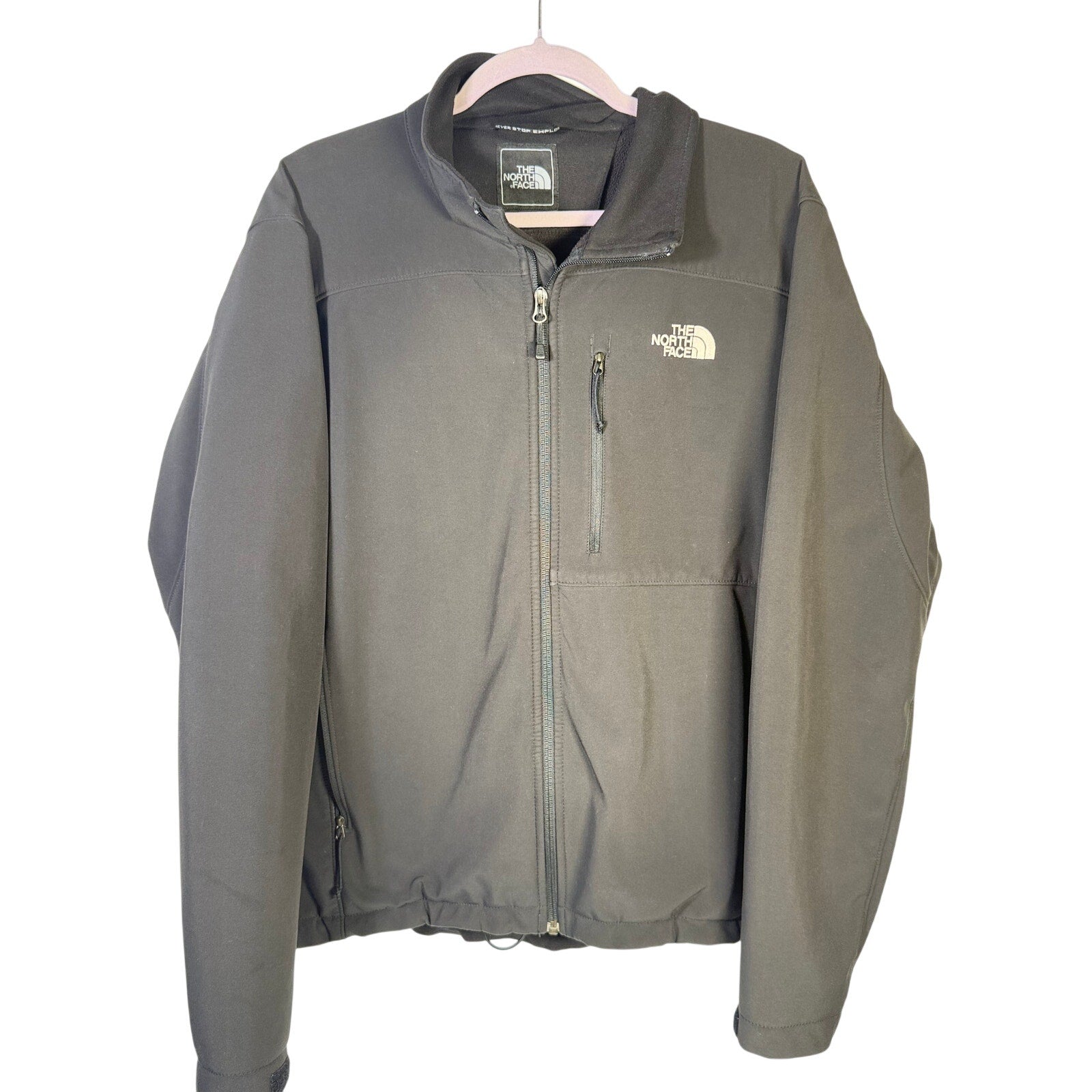 Black The North Face men's softshell jacket with full zip and fleece lining, featuring a high collar and durable fabric.
