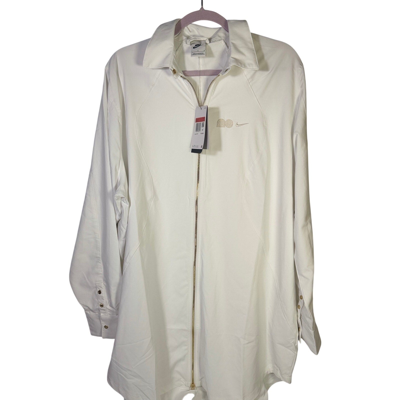 Nike women’s long full zip jacket in cream, size XL, with logo design, displayed on a hanger.