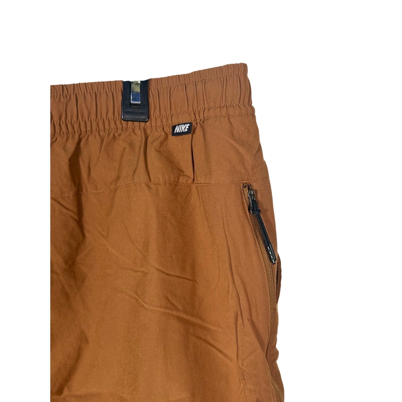 Nike Sportswear men's woven pants in brown Cacao with elastic waist, size XXL, shown laid flat.