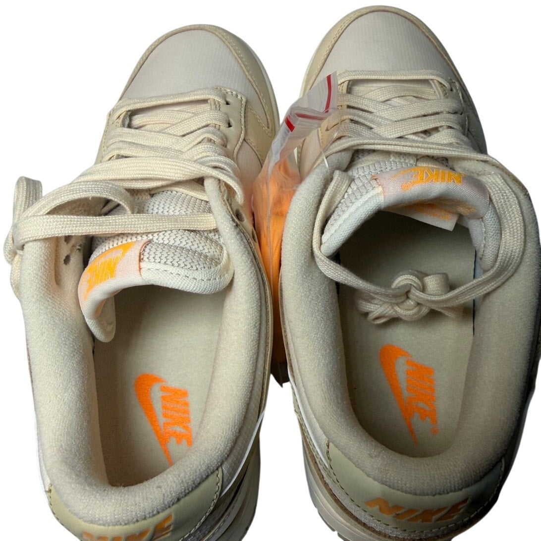 Nike Dunk Low women's sneakers in gold and white, featuring a low-cut design and Nike branding, size 6.5.