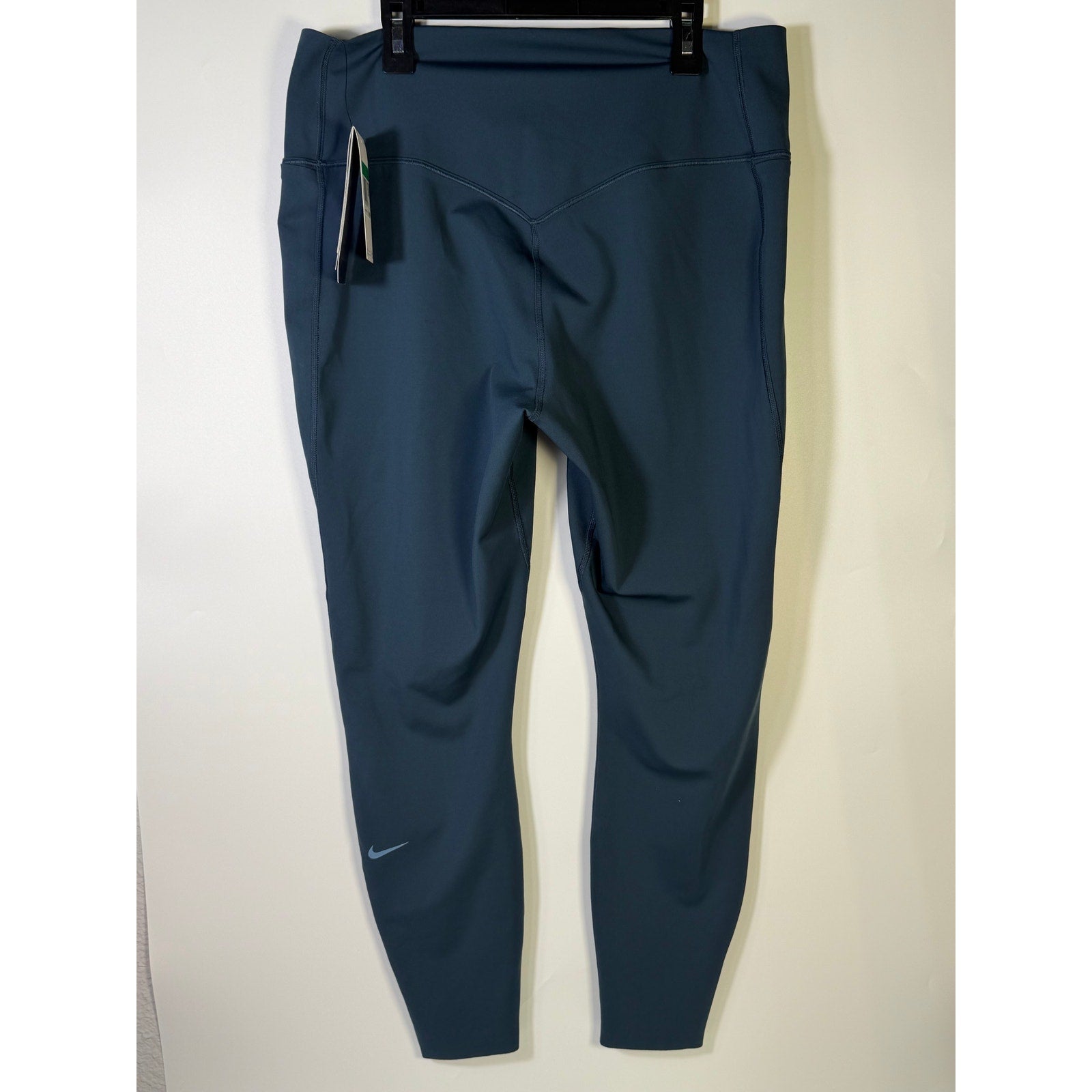 Nike women's blue high-waisted training leggings, XL size, shown laid flat with elastic waistband and smooth stretch fabric.