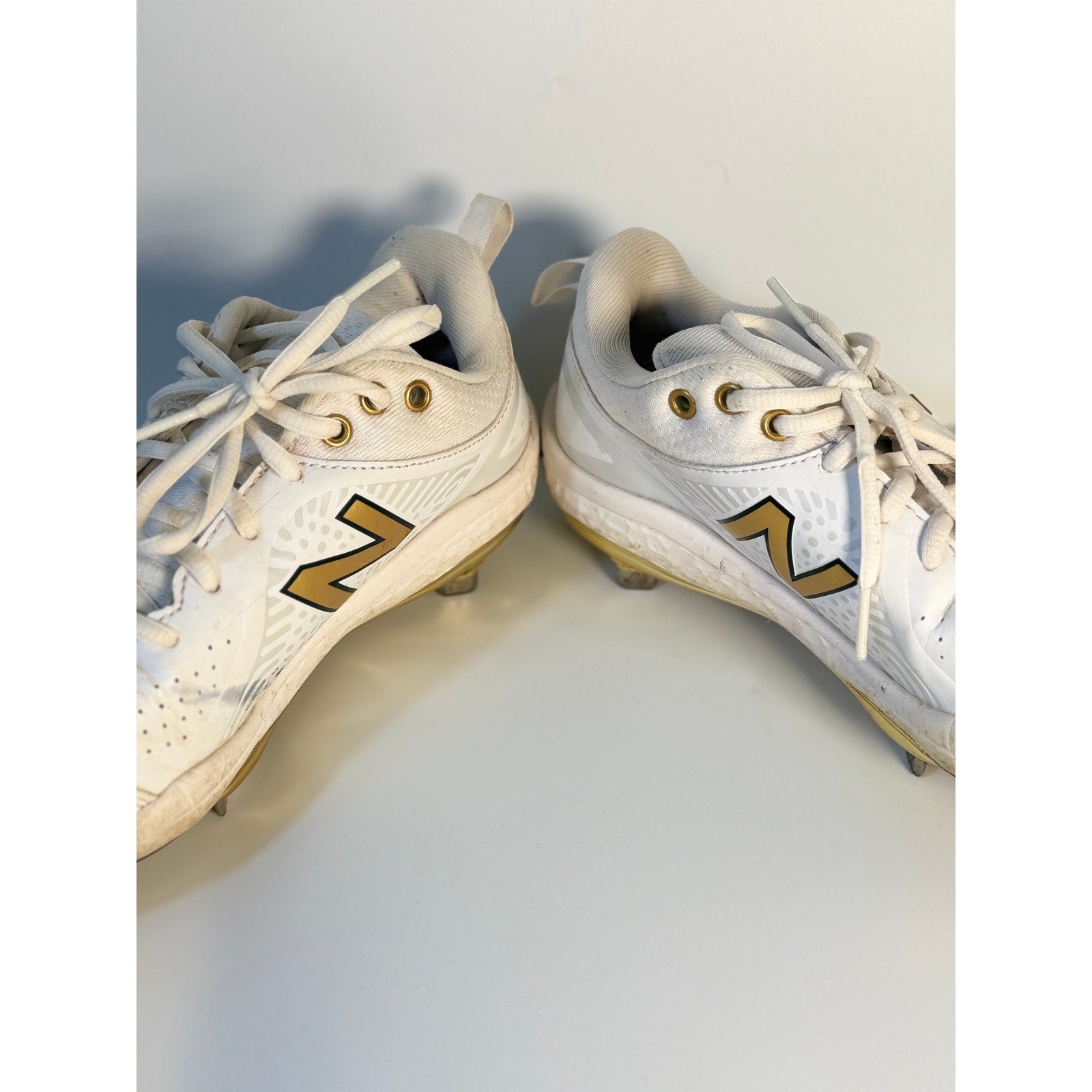 New Balance FuelCell COMPv2 baseball cleats for men, white and gold metal cleats, size 7.5, showing the athletic shoe design.