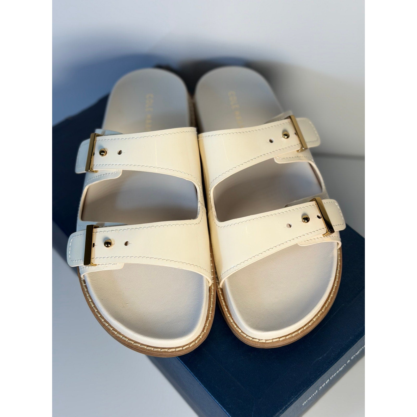 Cole Haan women's white leather buckle slide sandals, US size 9B, with open toe design and stylish strap details.