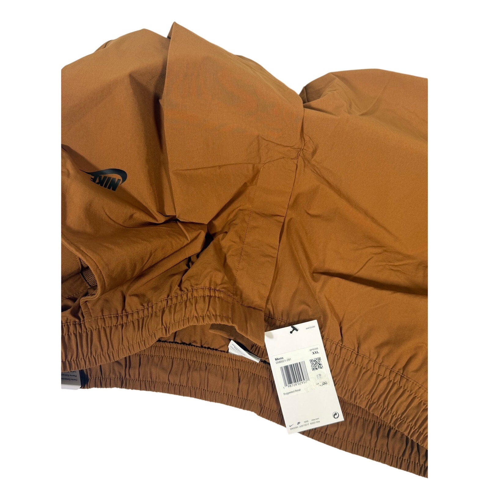 Nike Sportswear men's woven pants in brown cacao with elastic waist, size XXL, shown flat on white background.