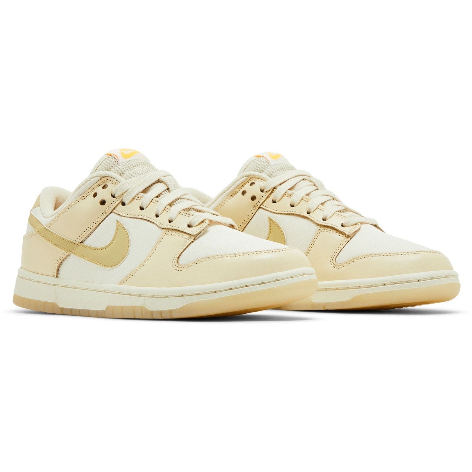 Nike Dunk Low women's sneakers in gold and white, size 6.5, featuring a stylish low-cut design and Nike branding.