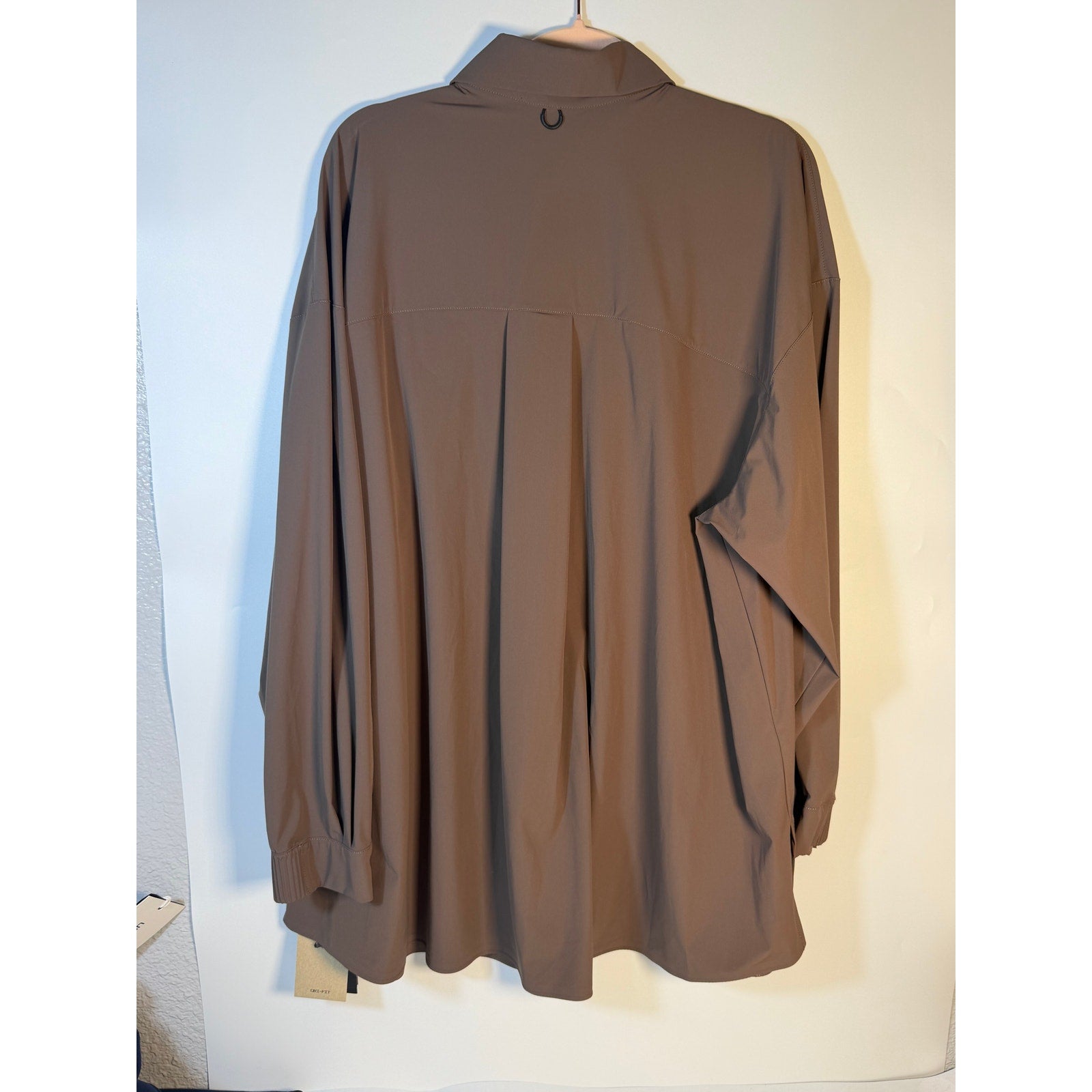 Nike 24.7 Women's XL brown Dri-FIT training button-front shirt, made of breathable fabric, shown on a hanger.