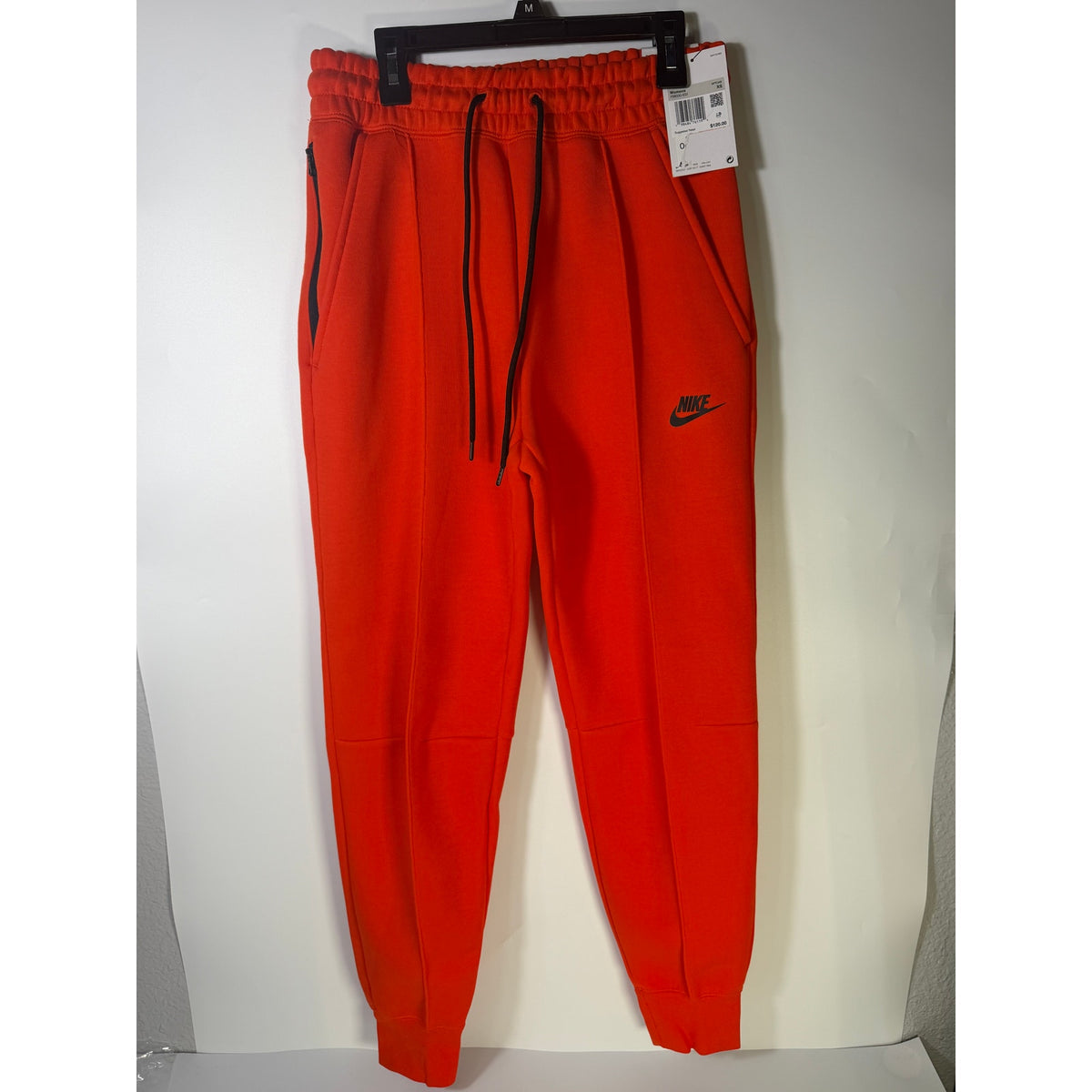 Bright orange Nike Sportswear Phoenix Fleece Jogger Pants for women, mid-rise fit, XS size, with a relaxed style and fleece material.