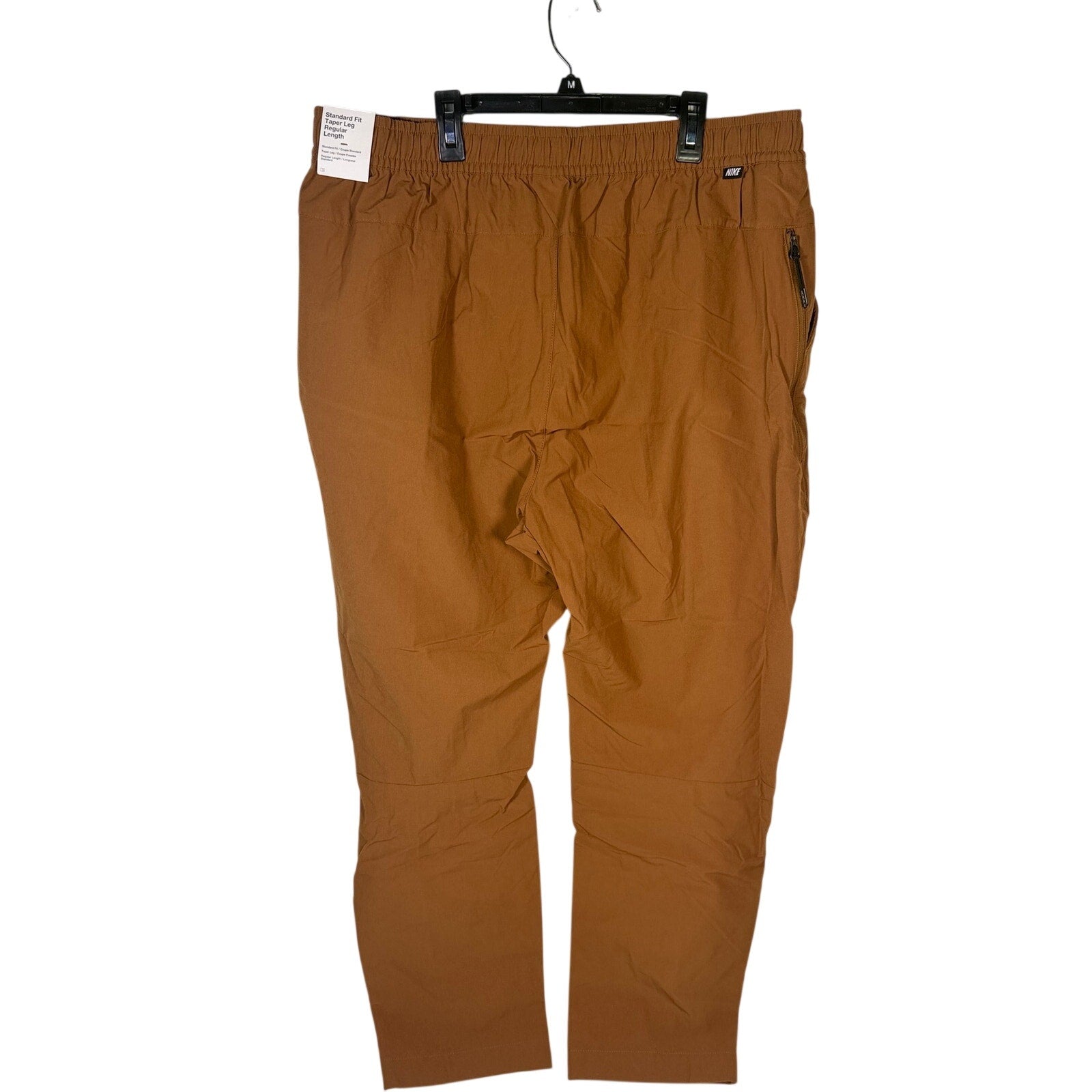Nike Sportswear men's woven brown cacao pants with elastic waistband, size XXL, shown flat on a white background.