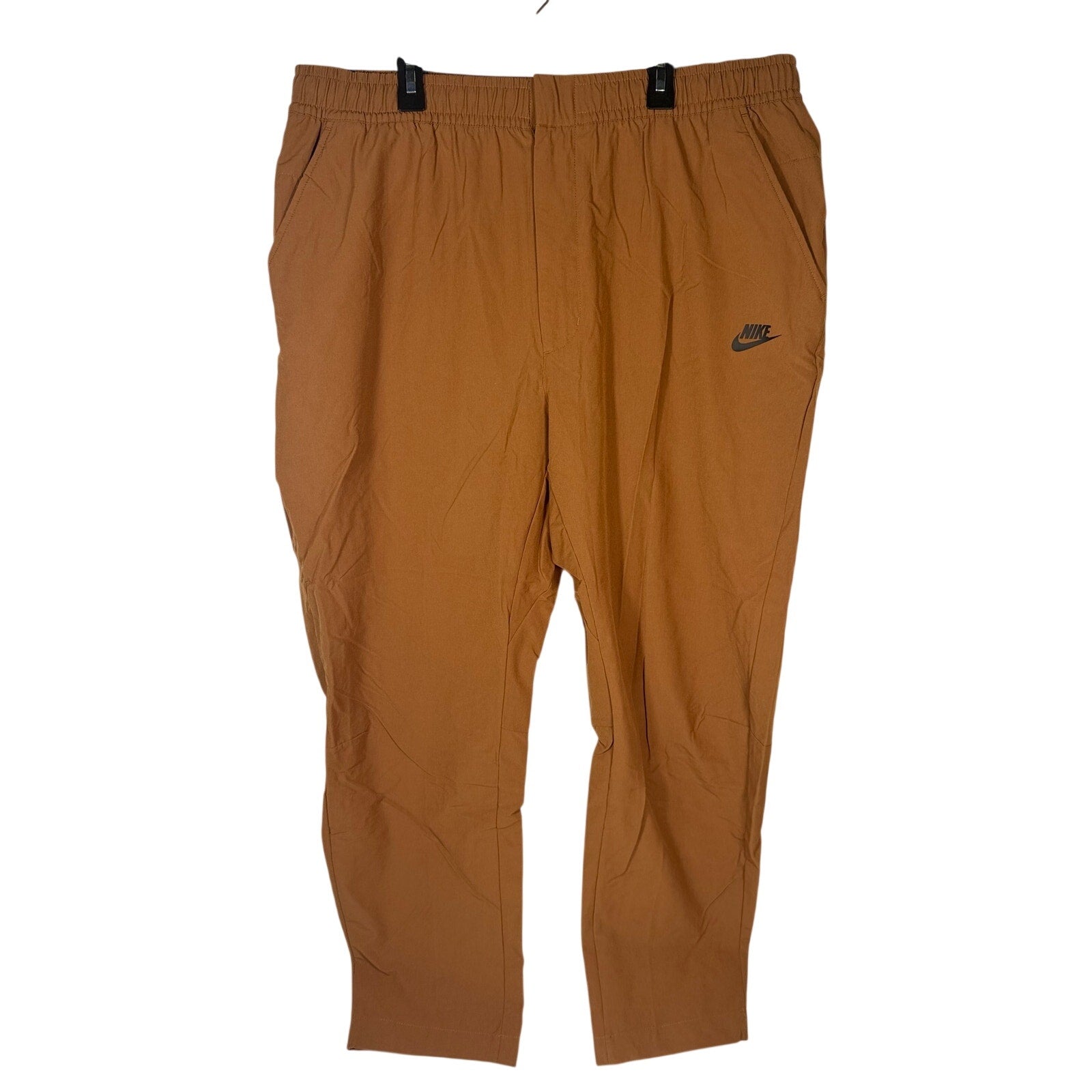 Nike Sportswear men's woven pants in brown cacao with elastic waist, size XXL, shown flat on a white background.