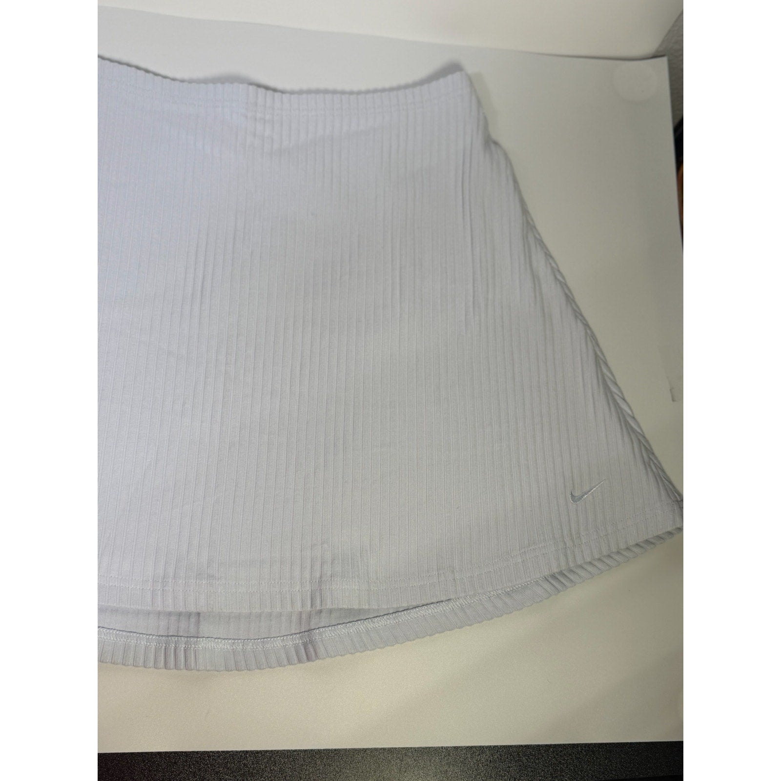 Nike women's ribbed mini skirt in sapphire mist color, size M, featuring a fitted style with textured ribbed fabric.