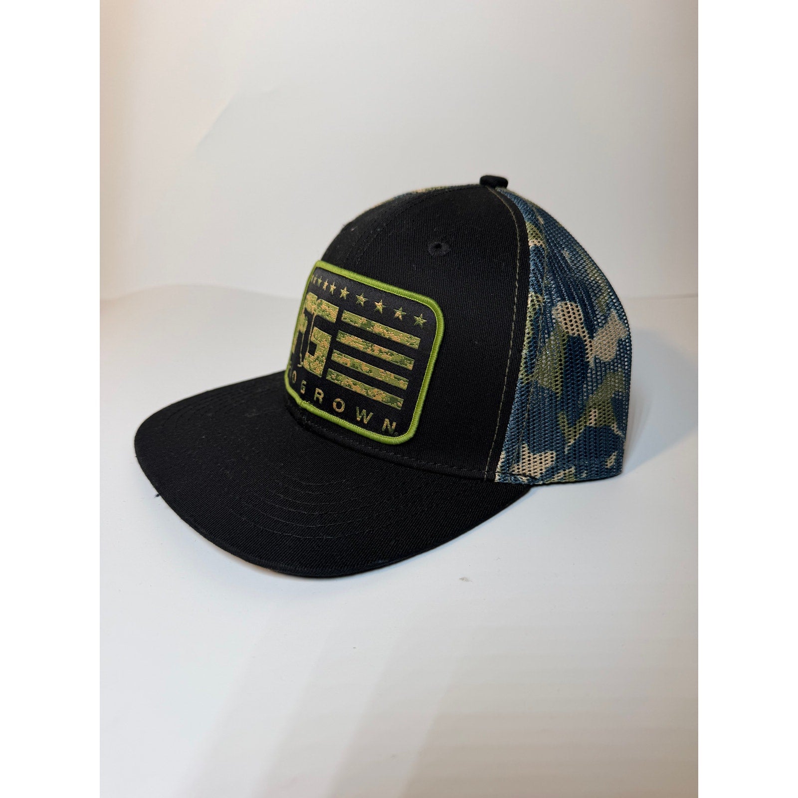 Black camo mesh trucker hat by FloGrown with Florida flag design, adjustable snapback cap for casual wear.