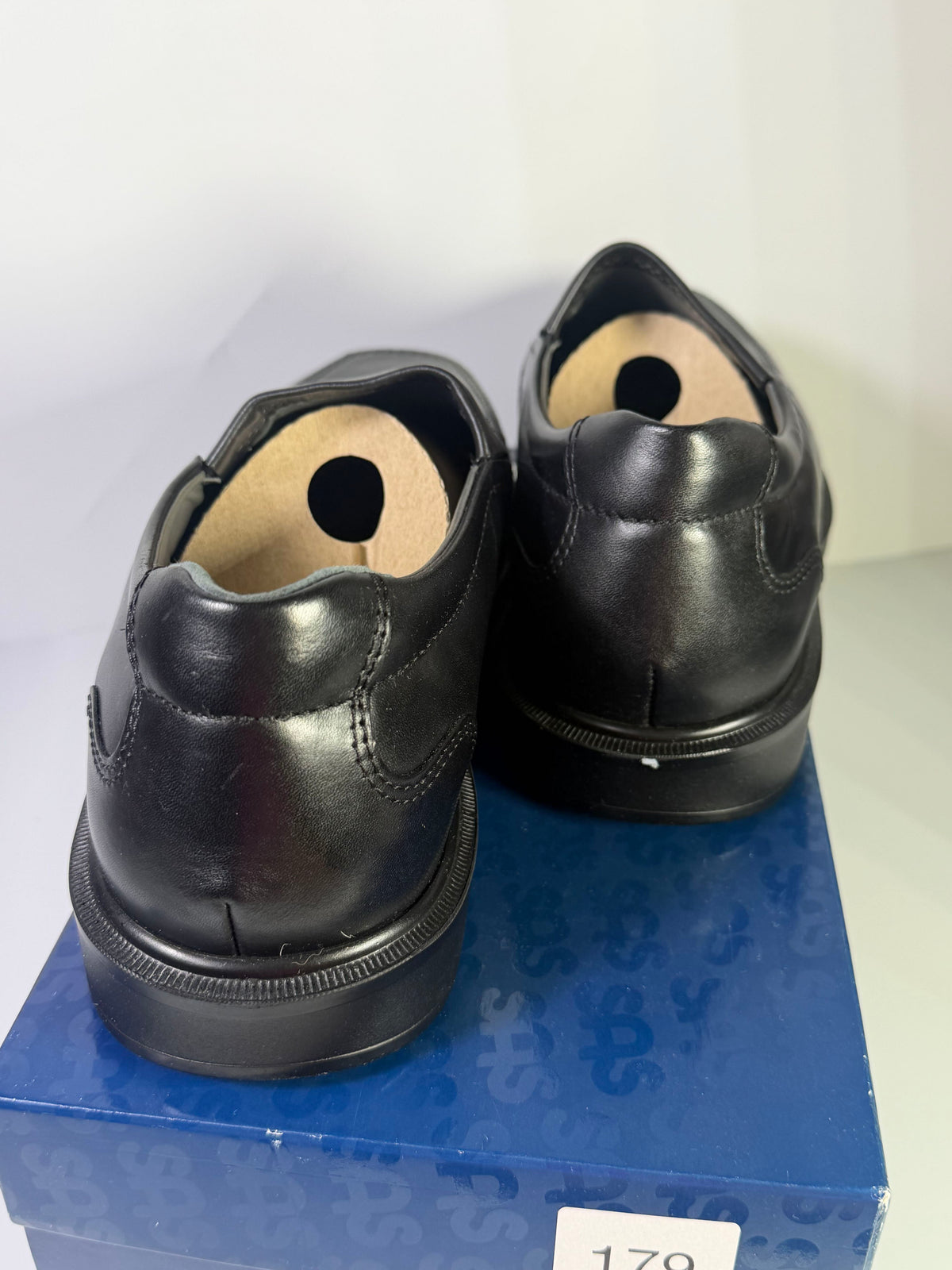 Black leather slip-on loafers for men by SAS, size 11.5W, featuring a sleek design and comfortable flat style.