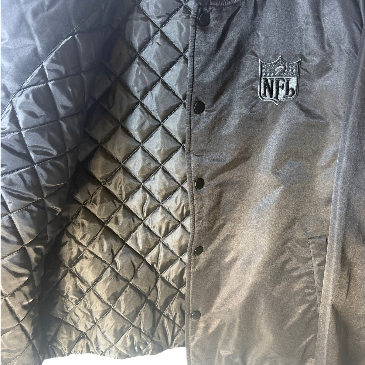 NFL men's varsity bomber jacket in black and gray with snap front, size large, featuring team logo and sporty design.
