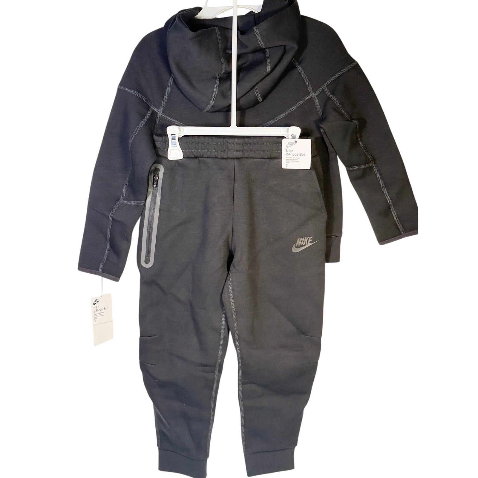 Nike Kids Tech Fleece full-zip hoodie and jogger set in black, size 7, featuring Nike branding and comfortable fleece material.