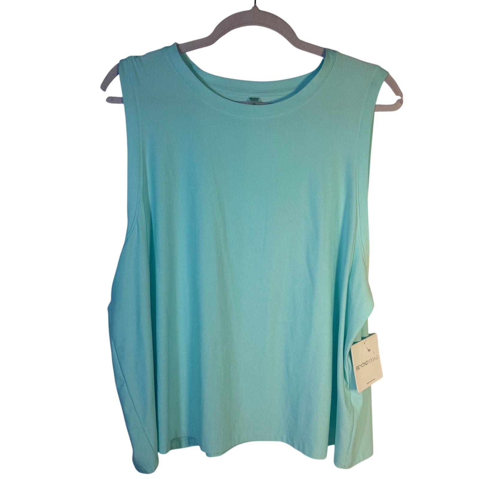 Beyond Yoga women's green sleeveless tank top displayed on a hanger, showcasing the relaxed fit and soft fabric.