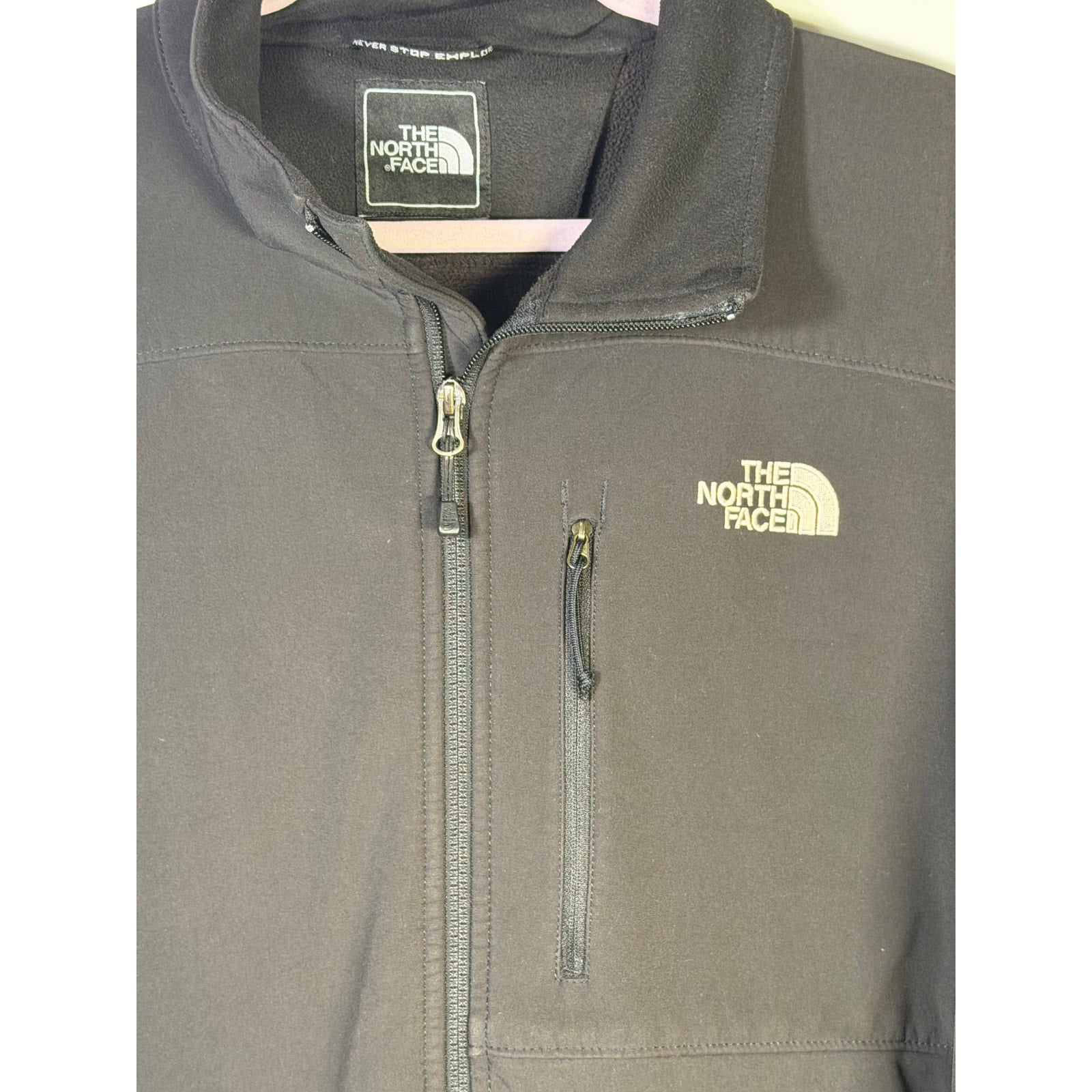 The North Face men's black softshell jacket with full zip and fleece lining, featuring a high collar and outdoor-ready design.