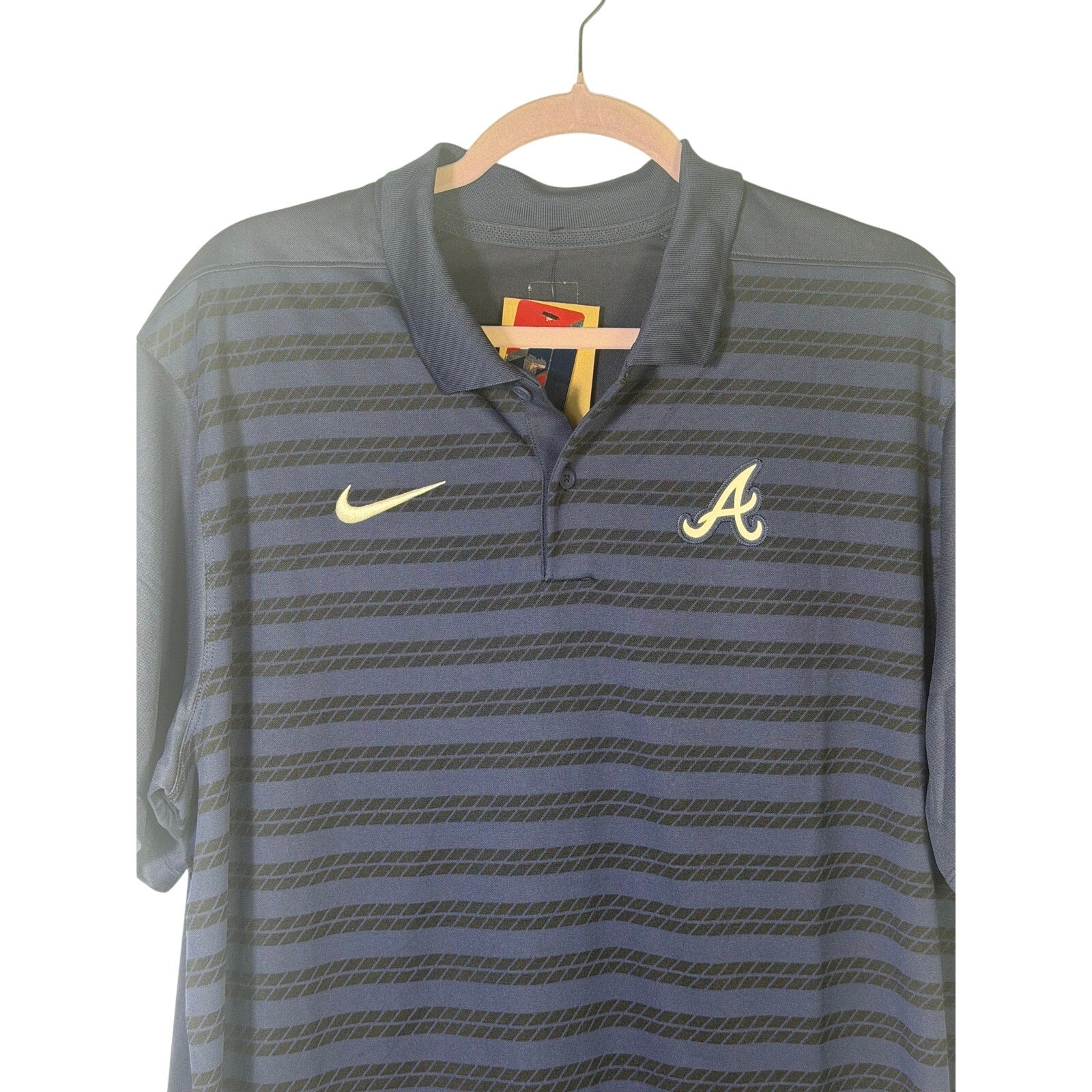 Nike Atlanta Braves men's Dri-FIT polo shirt in navy, size L, showing the front view with team logo and sporty fit.