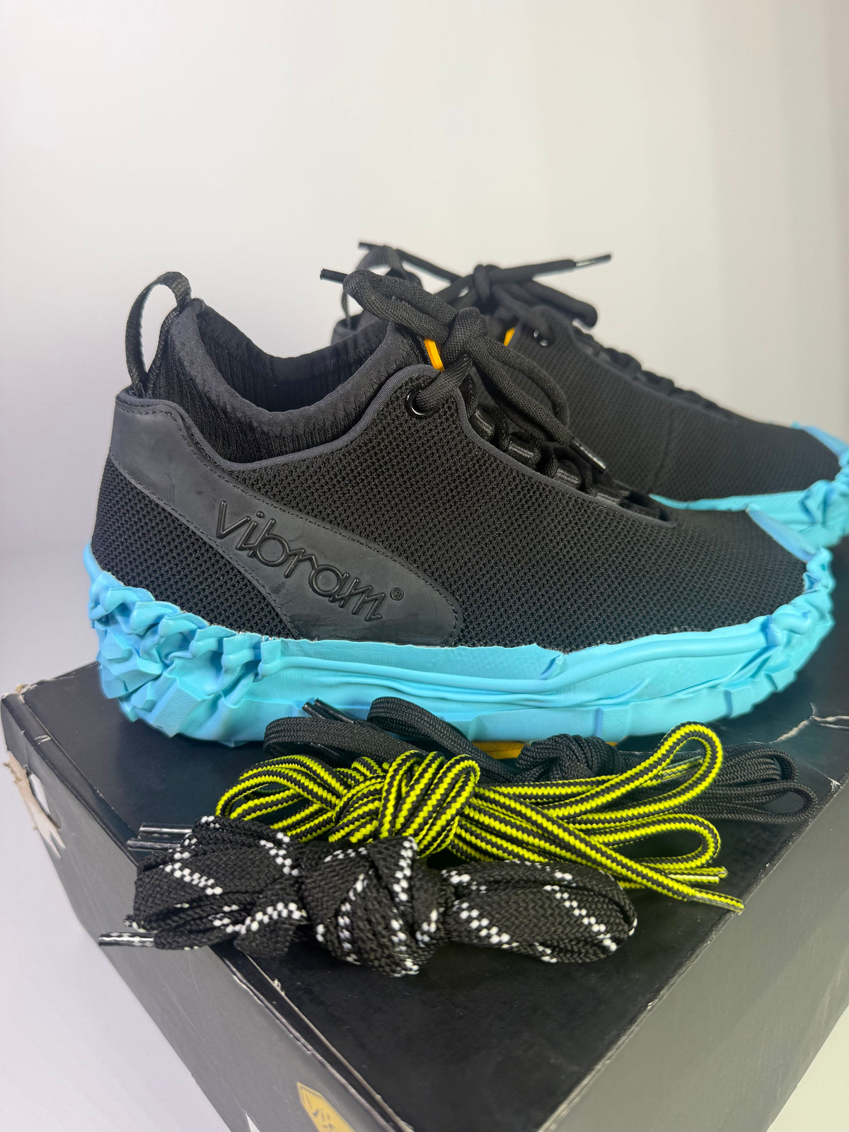 Vibram Wrap & Go athletic sneakers in black and sky blue, US size 6, with a sleek design and breathable fabric.