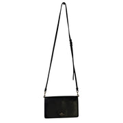 Black leather Coach women's foldover crossbody wallet bag with adjustable strap, featuring a compact handbag design.
