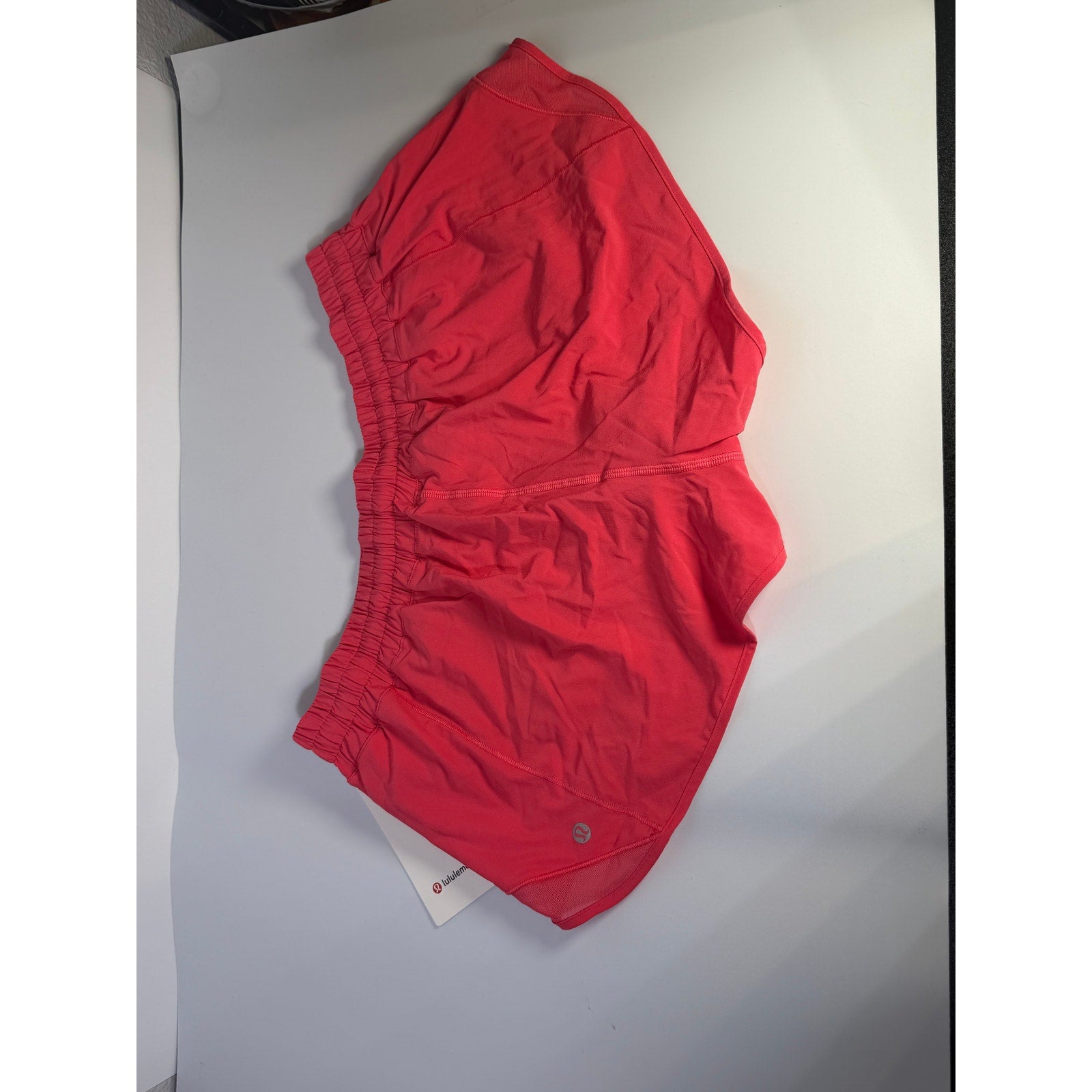 Lululemon Hotty Hot Low Rise Lined Shorts in Glaze Pink, women's size 14, showing the shorts laid flat with lining visible