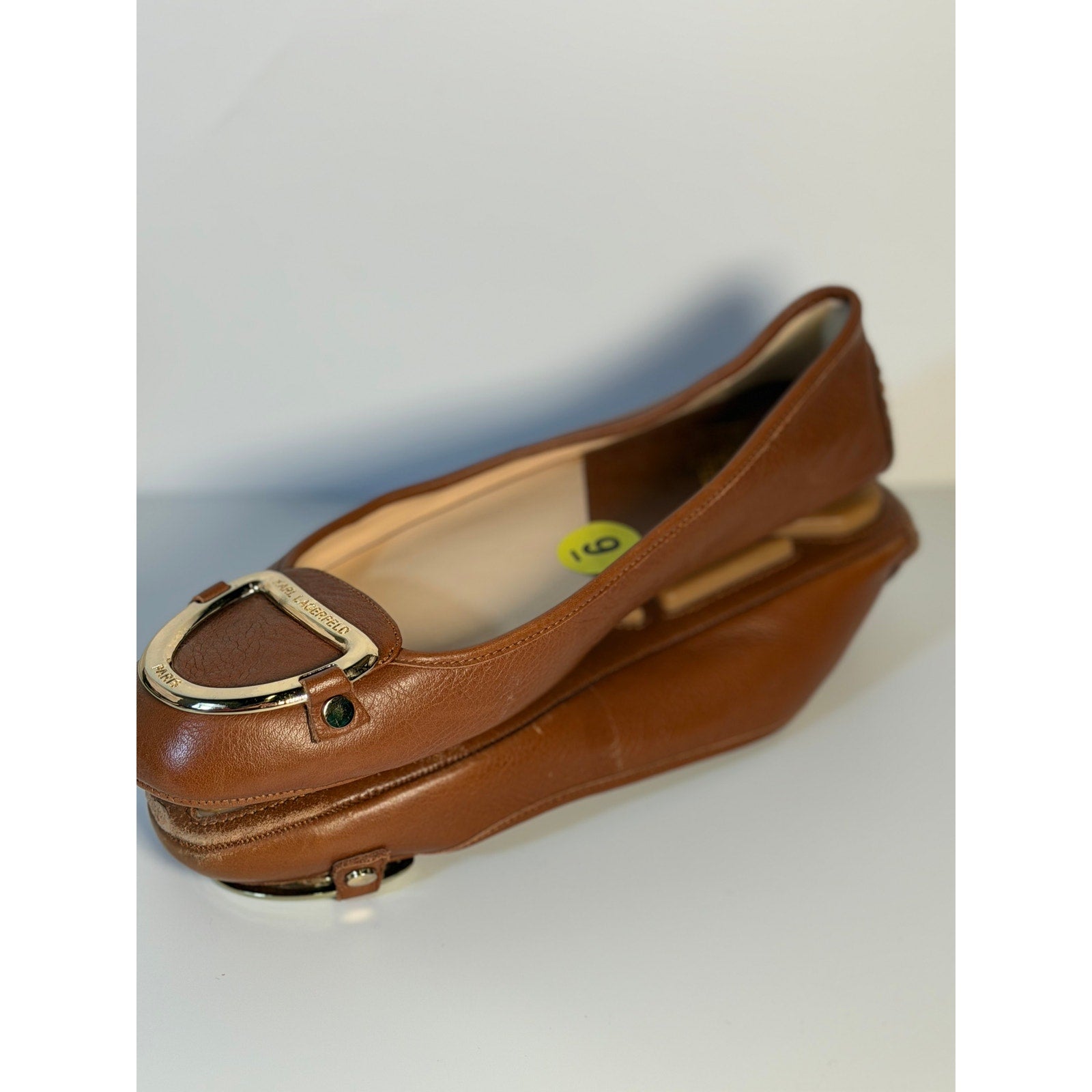 Brown Karl Lagerfeld Paris women's ballet flats with gold logo hardware, size US 9, pre-owned, comfortable slip-on shoes.