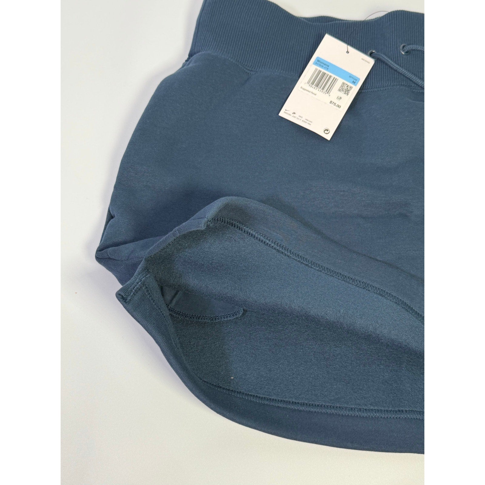 Nike women's navy blue fleece drawstring mini skirt, size M, showing the soft fabric and adjustable waistband.