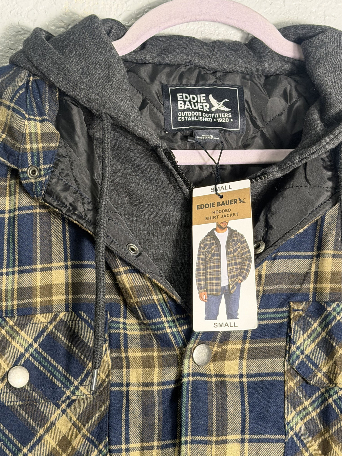 Eddie Bauer men's navy and tan plaid hooded flannel shirt jacket with quilted lining, size small, front view.