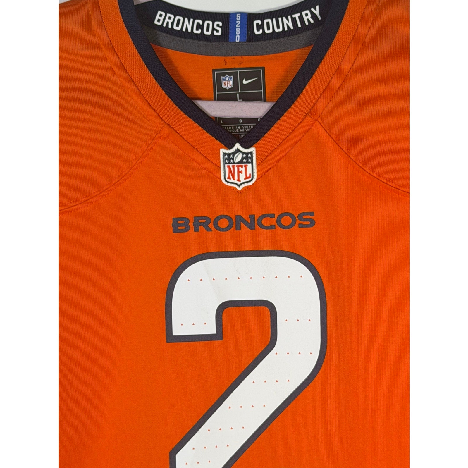 Nike youth Denver Broncos Patrick Surtain II #2 game jersey in orange, size L, featuring team and player details.