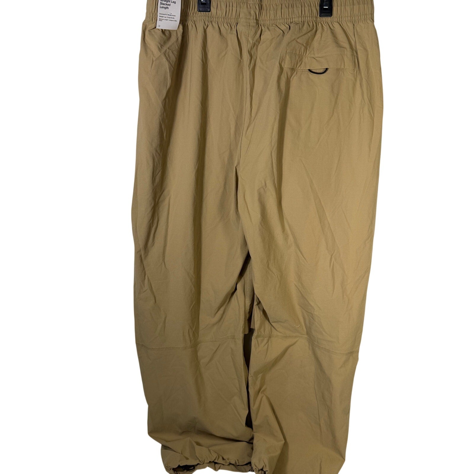 Nike Tech men's woven oversized parachute beige pants, size L, featuring a relaxed fit and breathable fabric.