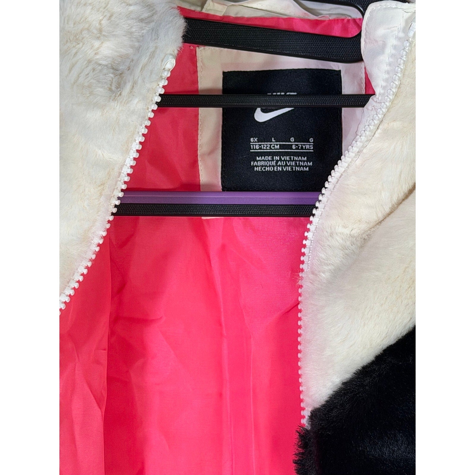 Nike girls' faux fur full-zip jacket in cream and black, size 6X, featuring an oversized swoosh logo.