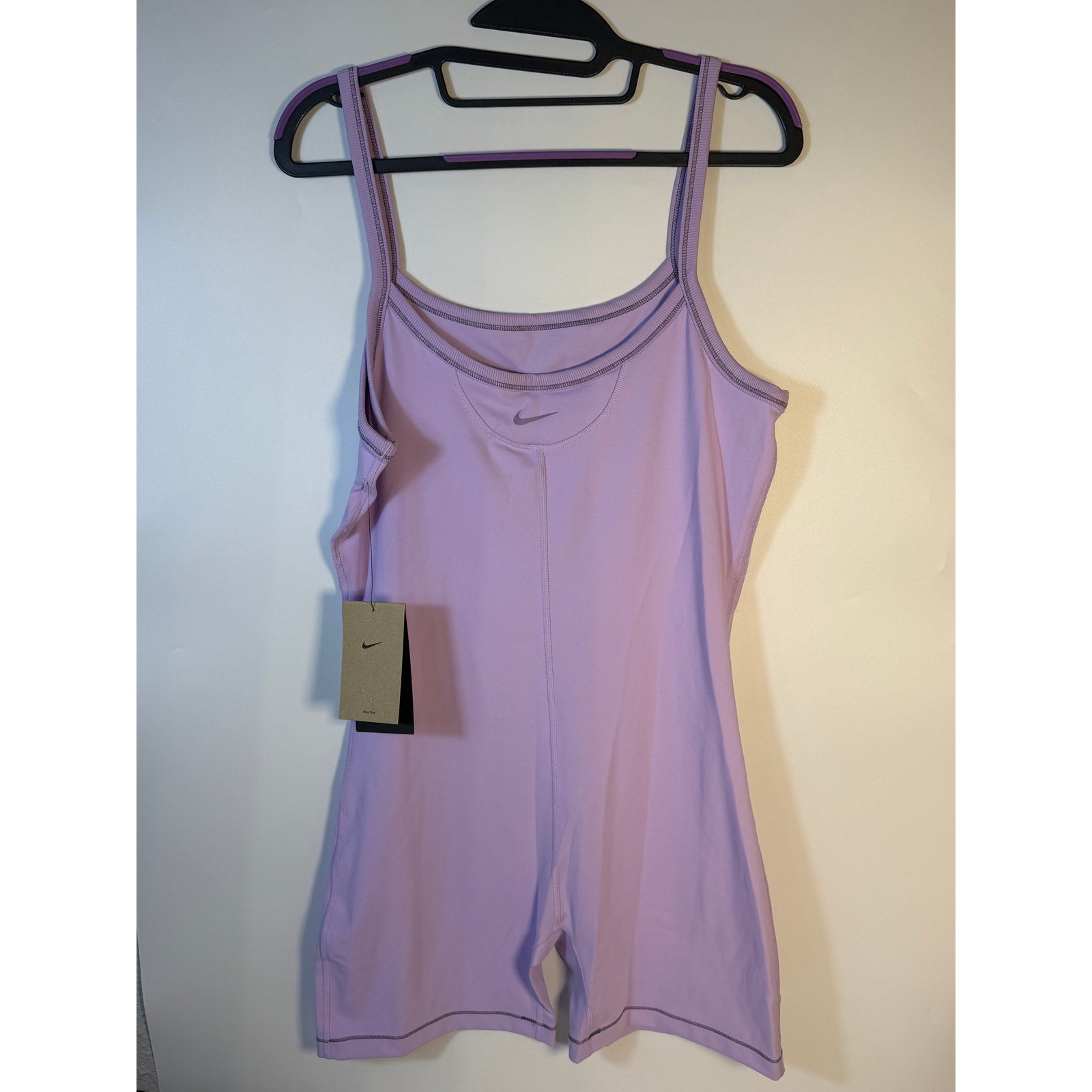 Lavender Nike One Dri-FIT training romper bodysuit for women in large size, shown on a model.