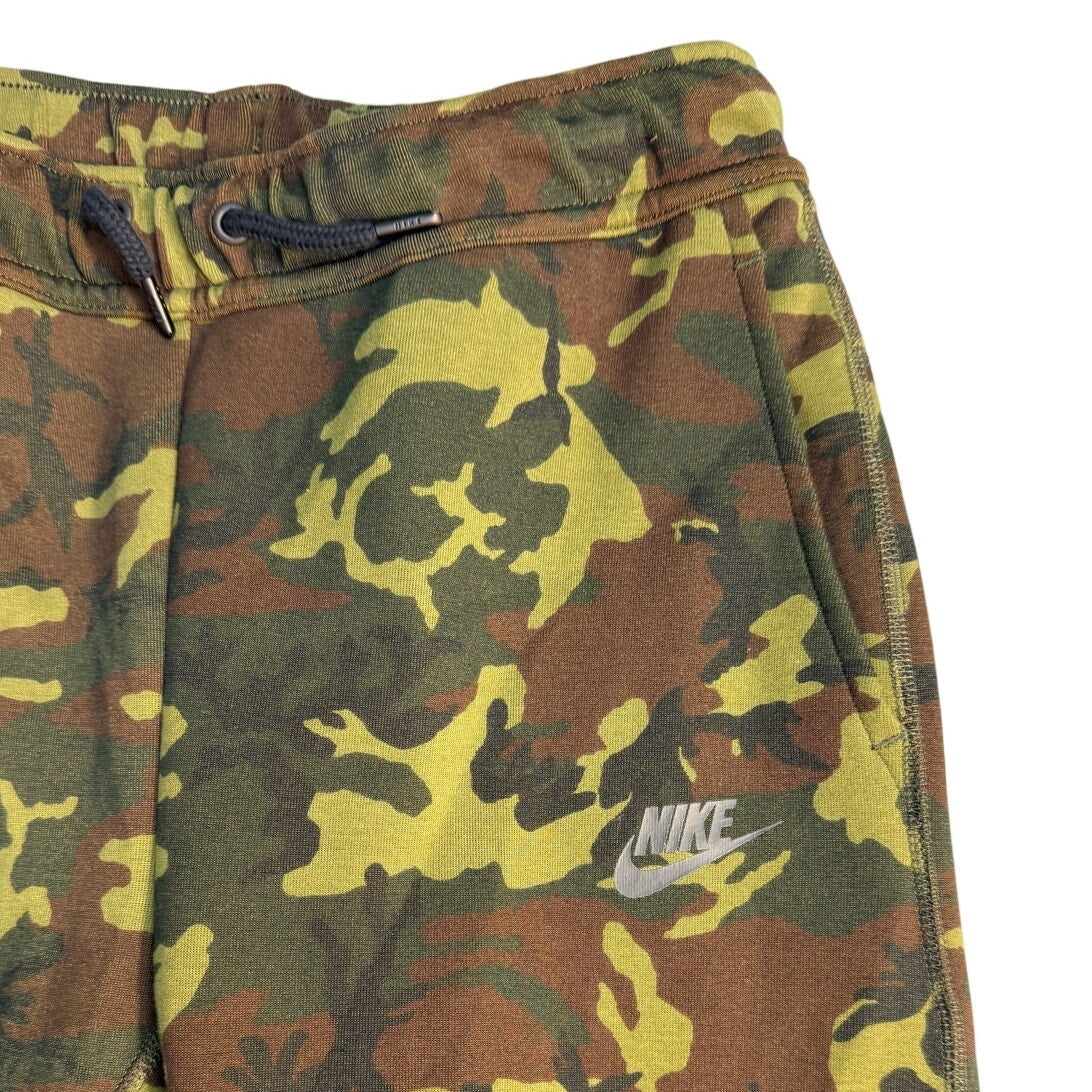 Youth large Nike Sportswear Tech Camo jogger pants with slim fit, featuring camouflage pattern and athletic design.