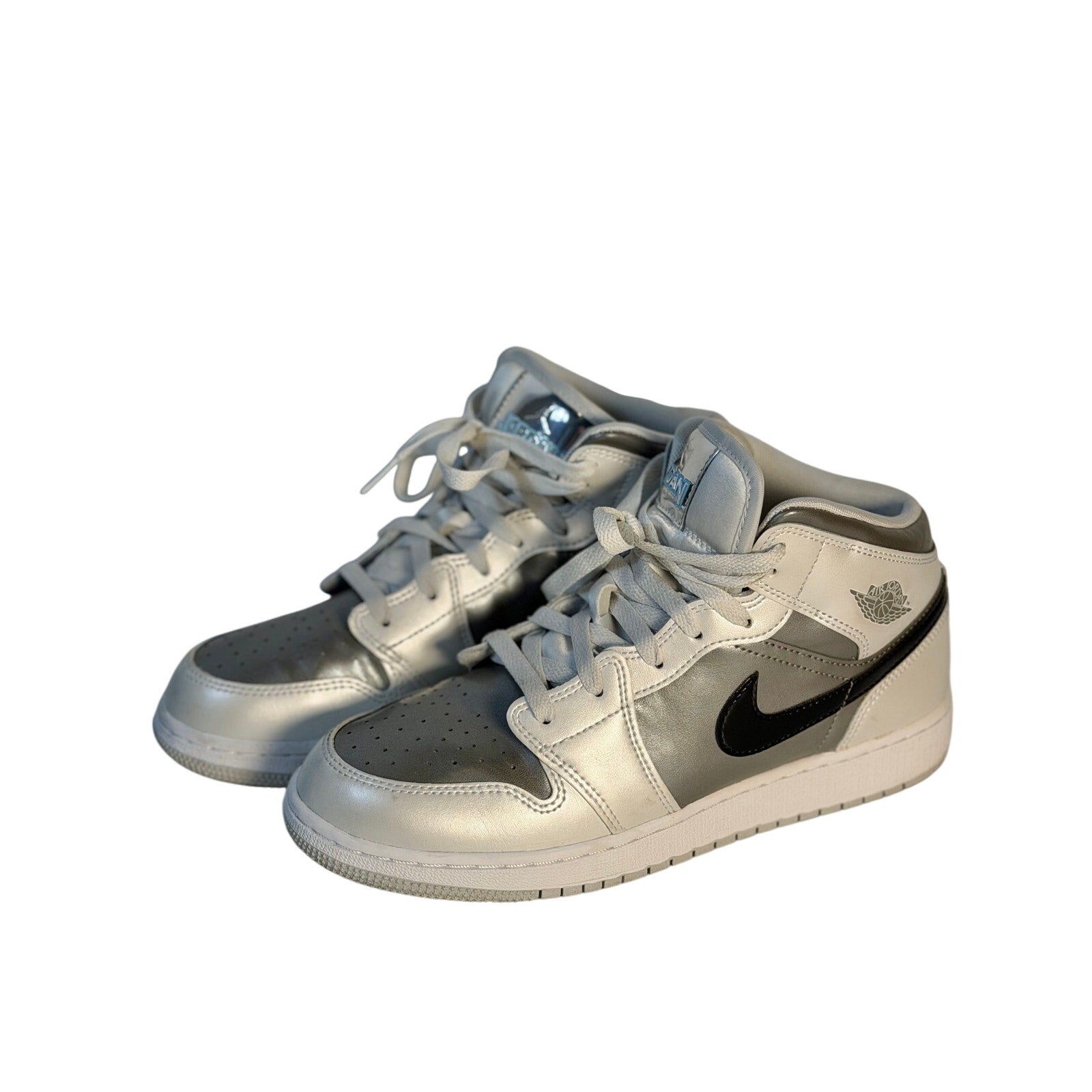 White, gray, and black Air Jordan 1 Mid GS sneakers for youth, size 7Y, featuring classic Jordan design and high-top style.