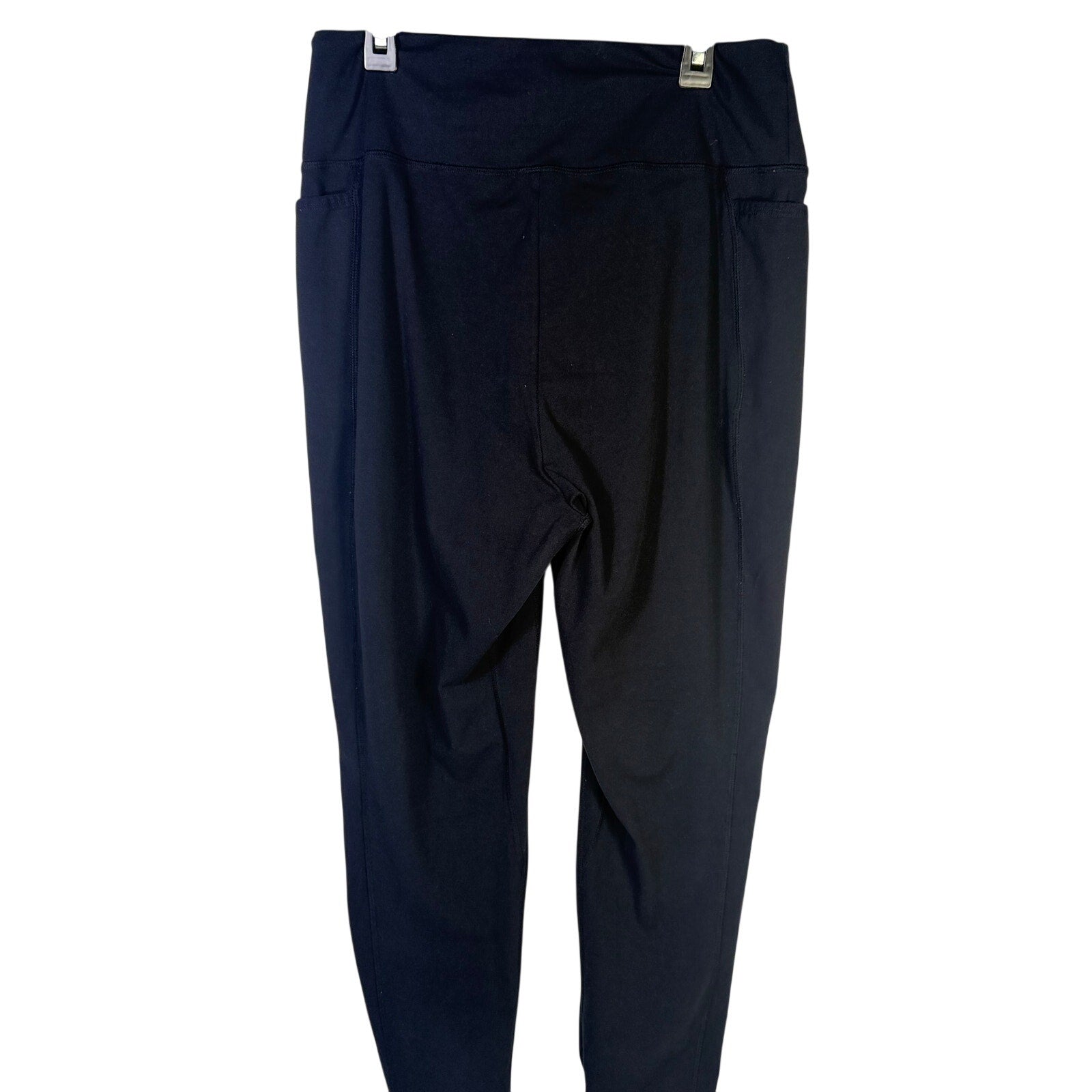 Black Gymshark women's high-waisted leggings with side pockets, size L, shown on a model standing in a gym setting.