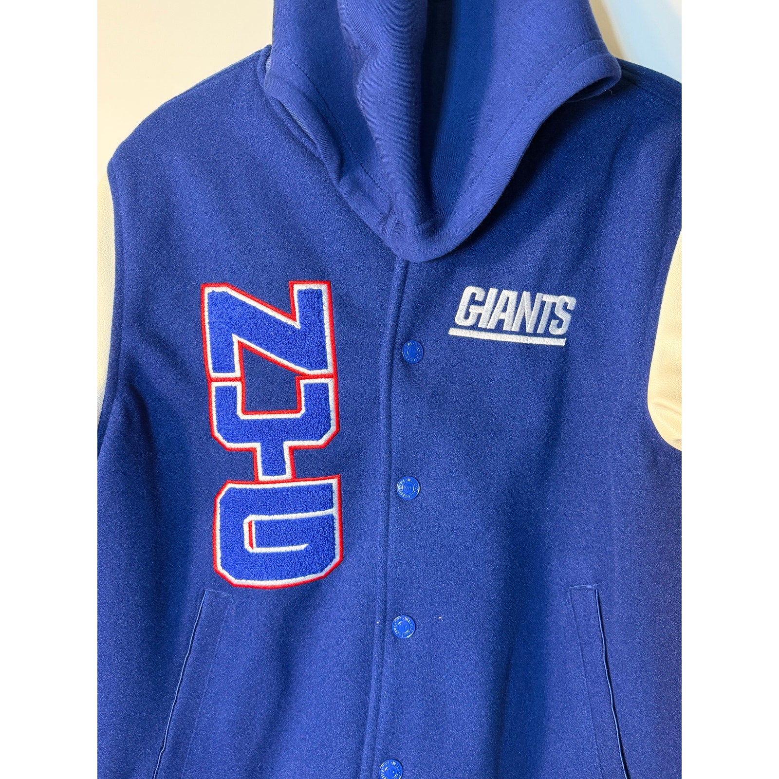 New York Giants women's varsity hooded jacket in blue and white, NFL Wild Collective jacket with team logo and varsity style.
