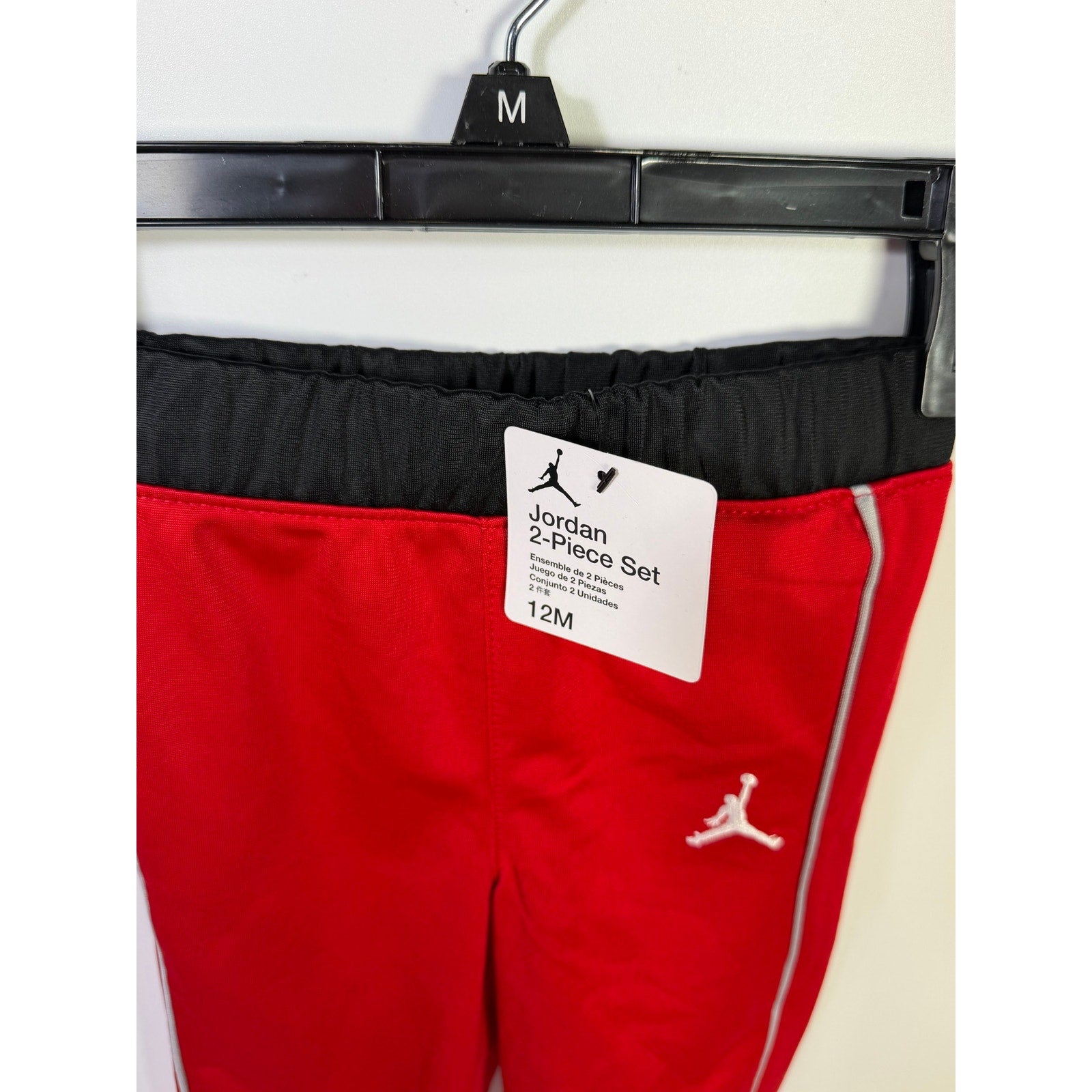 Jordan baby boys 2-piece tracksuit with red and black jacket and pants, suitable for 12 months, new with tags.