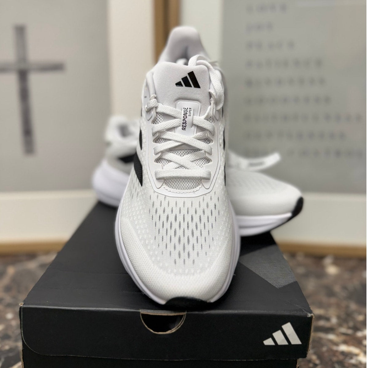 Adidas Response Super women's running sneakers in white, black, and silver with cushioned design and breathable mesh upper.