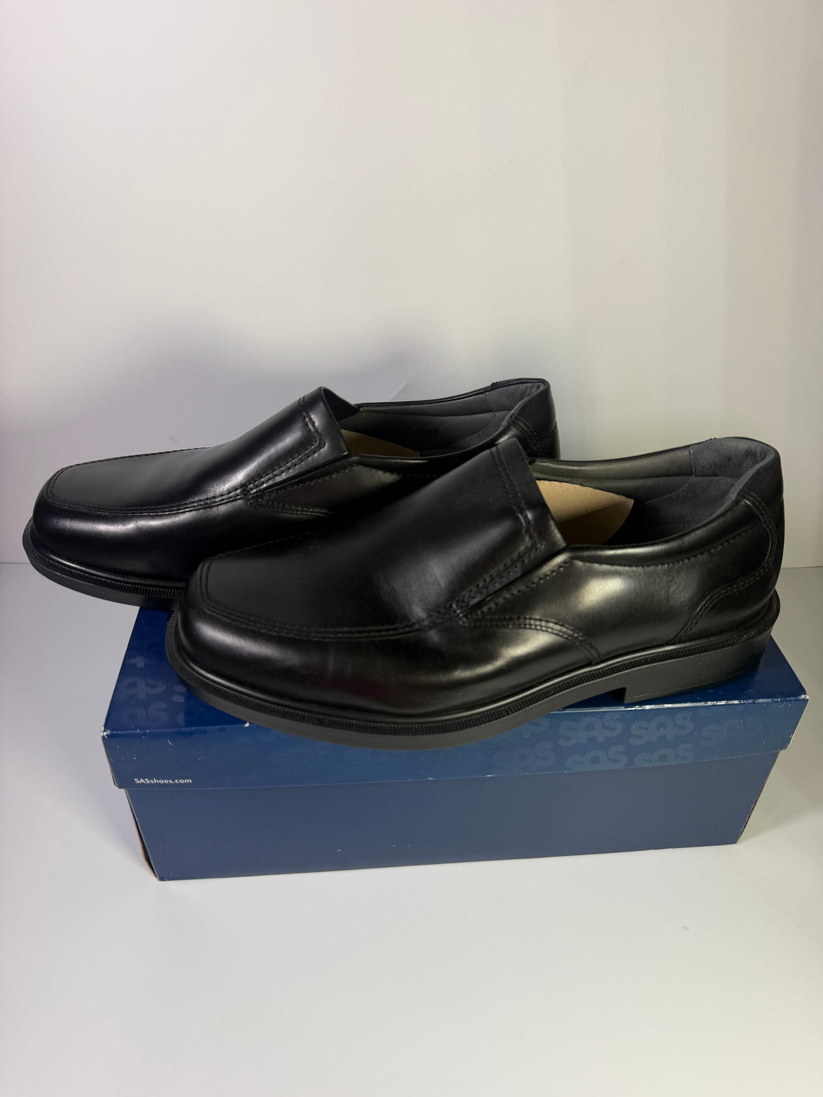 Black leather SAS men's slip-on loafers in size 11.5 wide with a sleek design, shown in new condition.