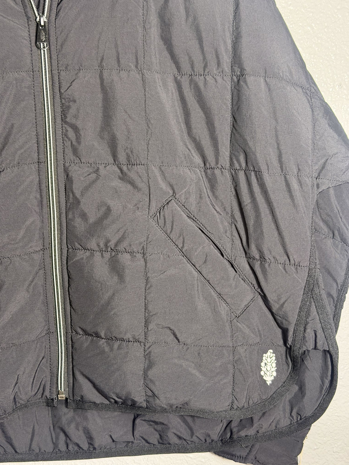 Black Free People Movement Pippa packable puffer jacket with PrimaLoft insulation, women's size XS, shown folded and ready to wear.