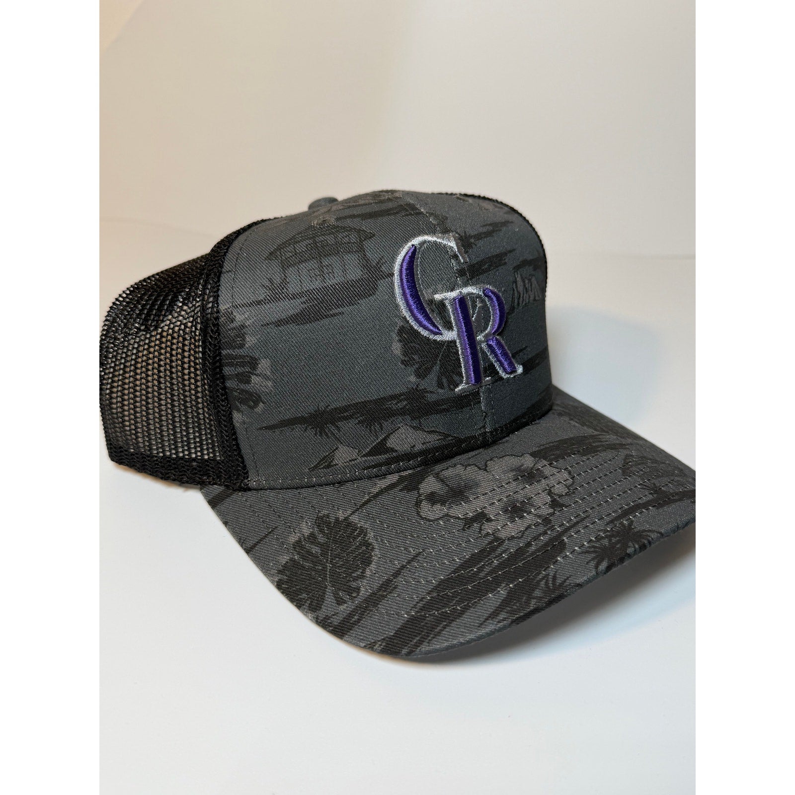 Gray and black 47 Brand Colorado Rockies trucker hat with floral design, adjustable snapback, featuring embroidered team logo.