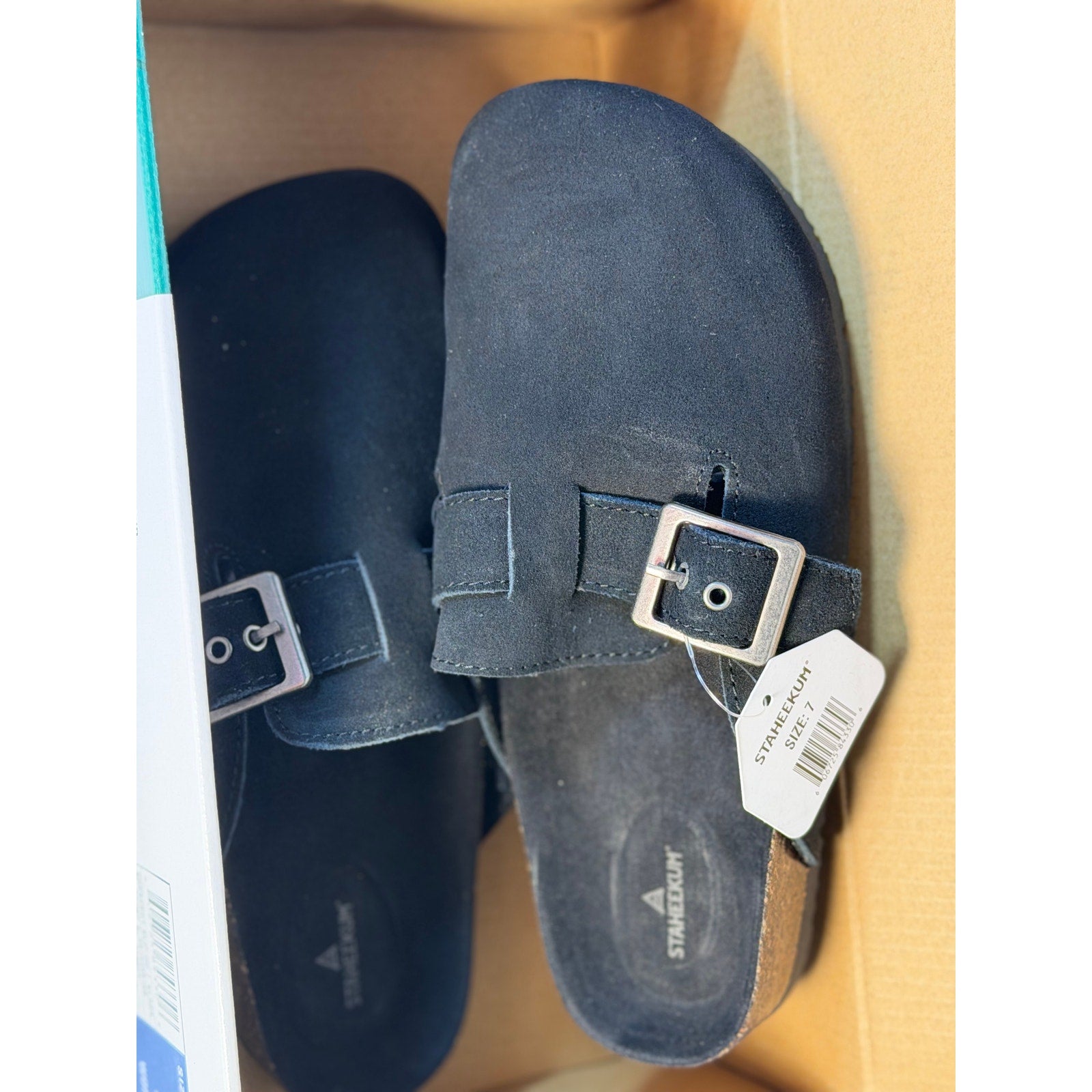 Black Staheekum women's buckle slip-on clogs, size 7, new with tags, shown from a side view on a plain background.