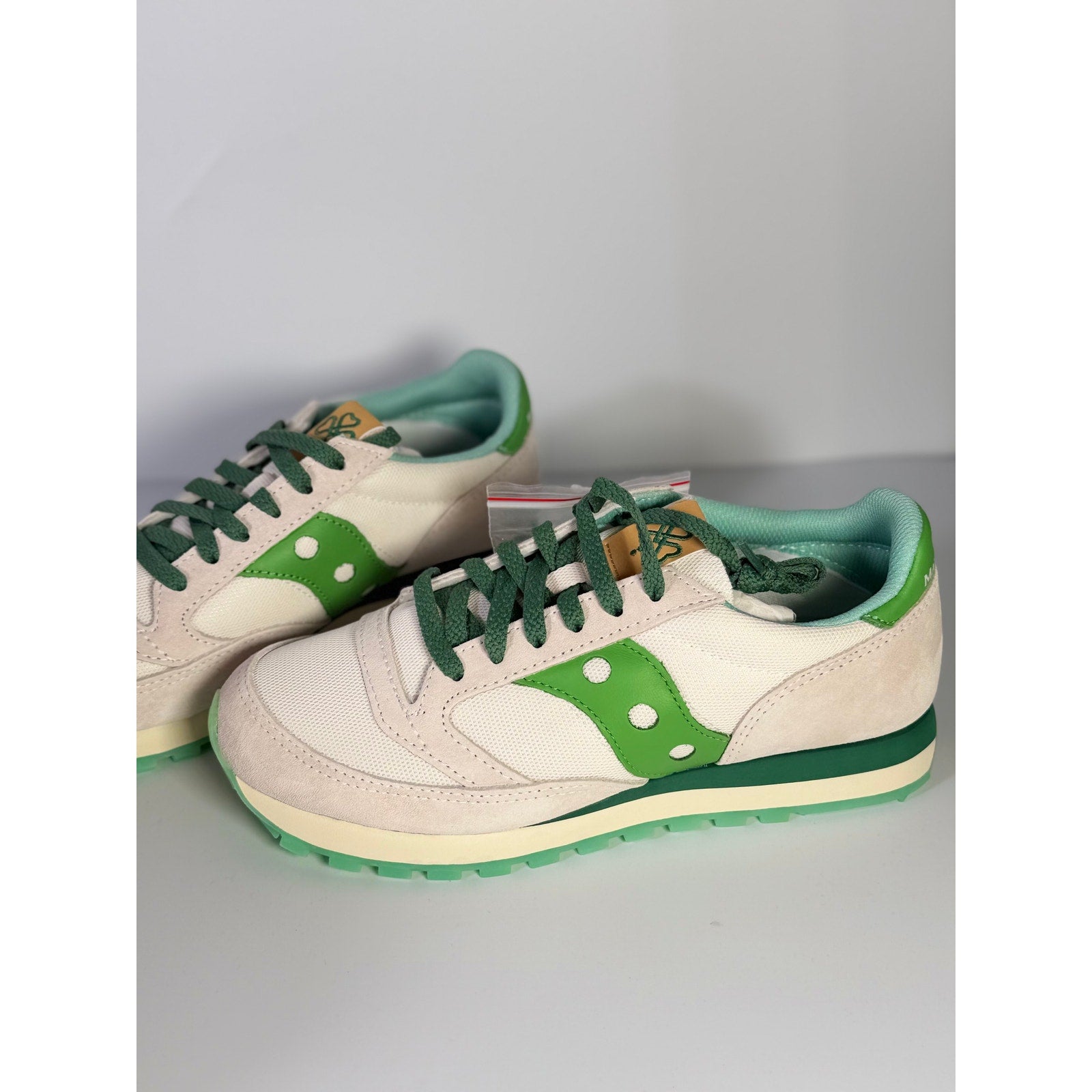 White and green Saucony Jazz Original sneakers for women, lace-up running shoes with a classic design and sporty style.