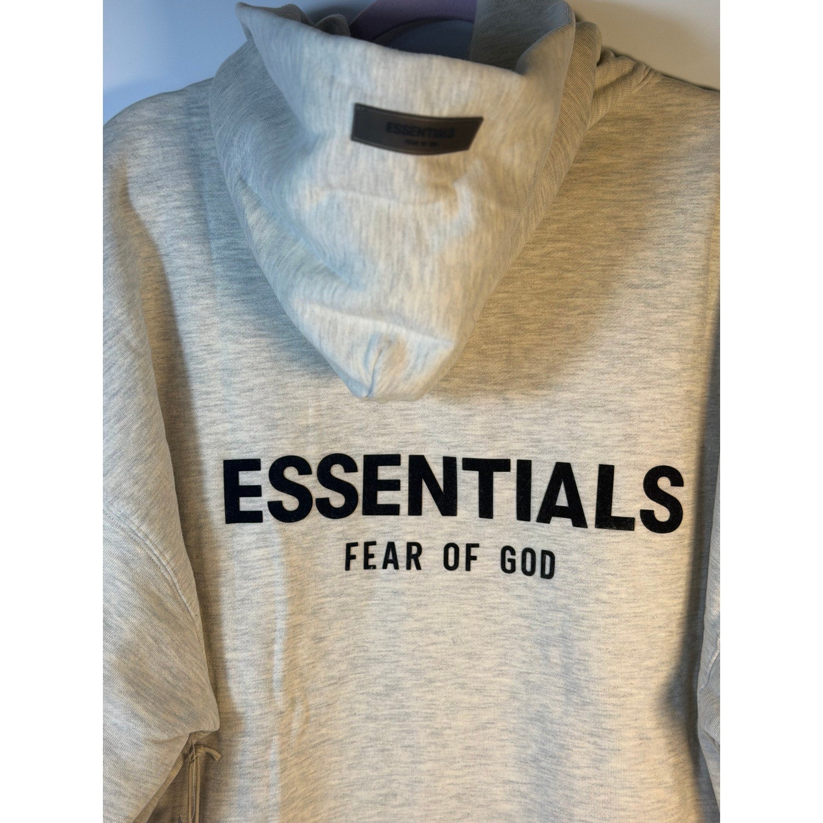 Fear of God ESSENTIALS men's light oatmeal hoodie with logo, pullover style, casual sweatshirt, front view, large size.