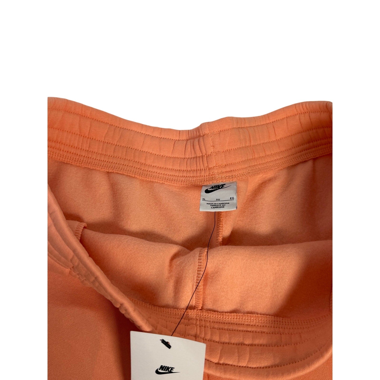 Nike women's peach orange fleece drawstring shorts with pockets, size XL, casual athletic style.