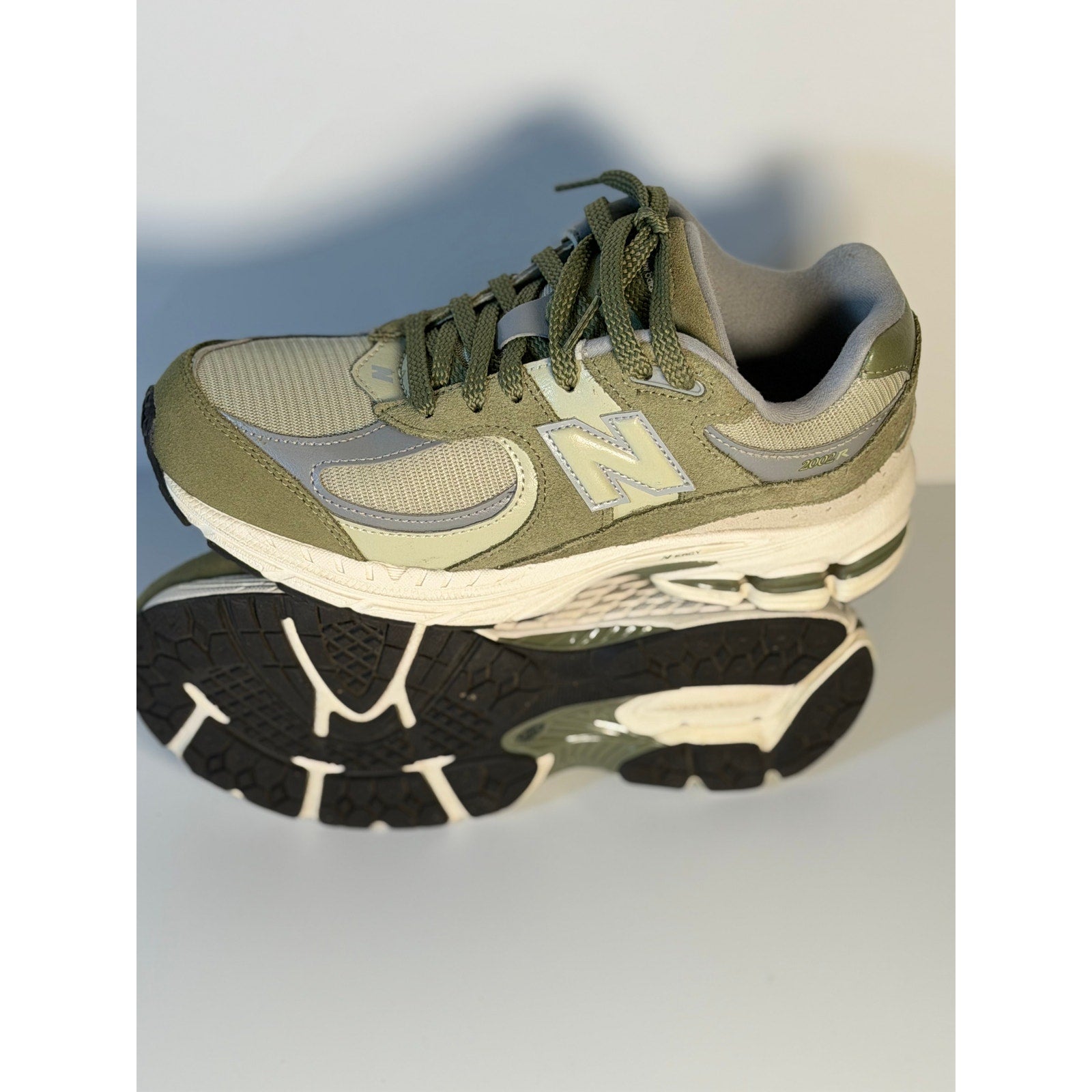 Pre-owned New Balance 2002R athletic sneakers in olive and gray for youth size 5.5, showing side view of the running shoes.