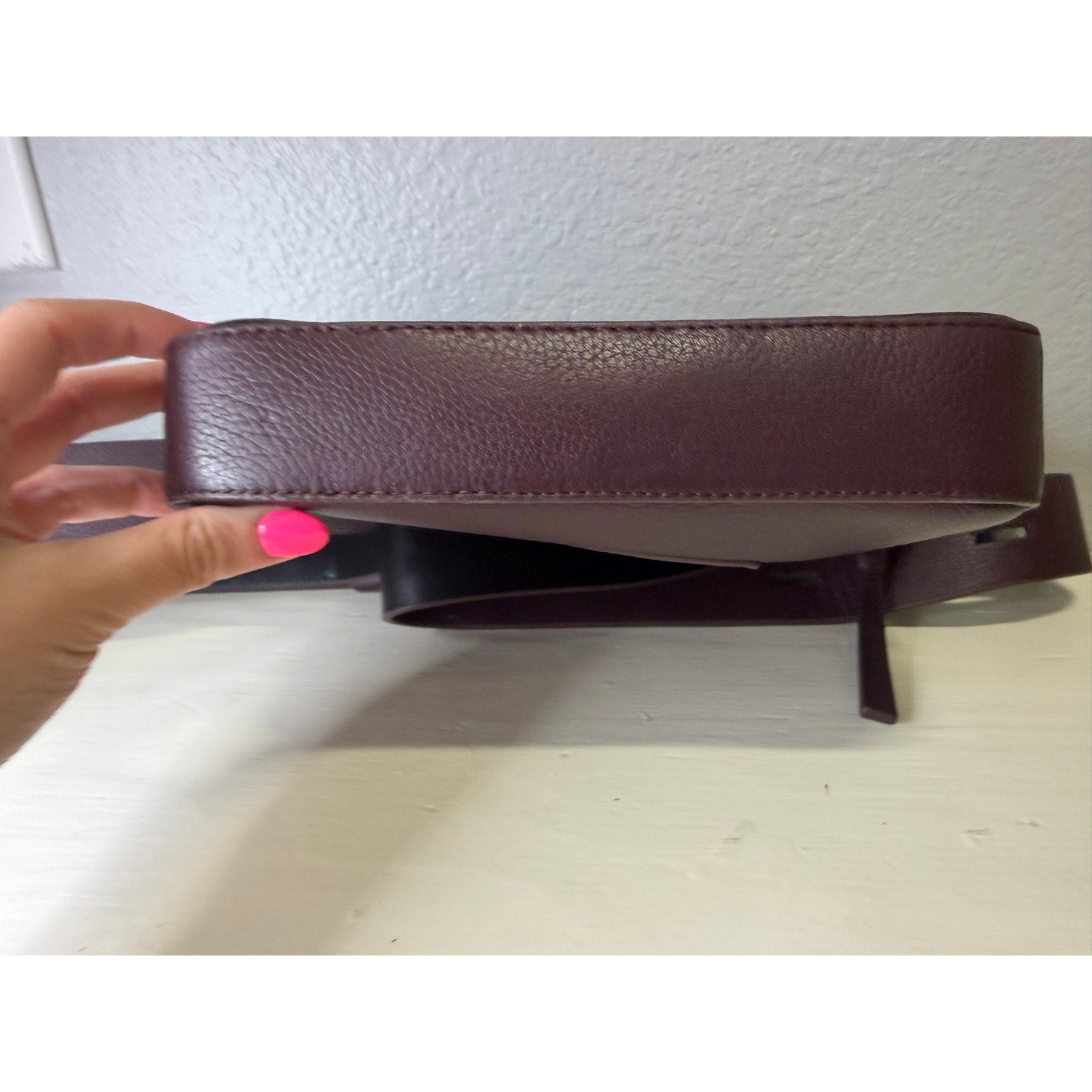 AllSaints burgundy pebbled leather camera crossbody bag with adjustable strap for women, stylish handbag accessory.