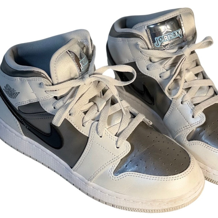 White, gray, and black Air Jordan 1 Mid GS sneakers for youth size 7Y, featuring classic Jordan design and high-top style.