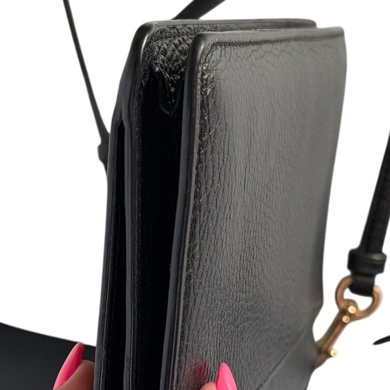 Coach women's black leather foldover crossbody wallet bag with adjustable strap, featuring a sleek and stylish handbag design.