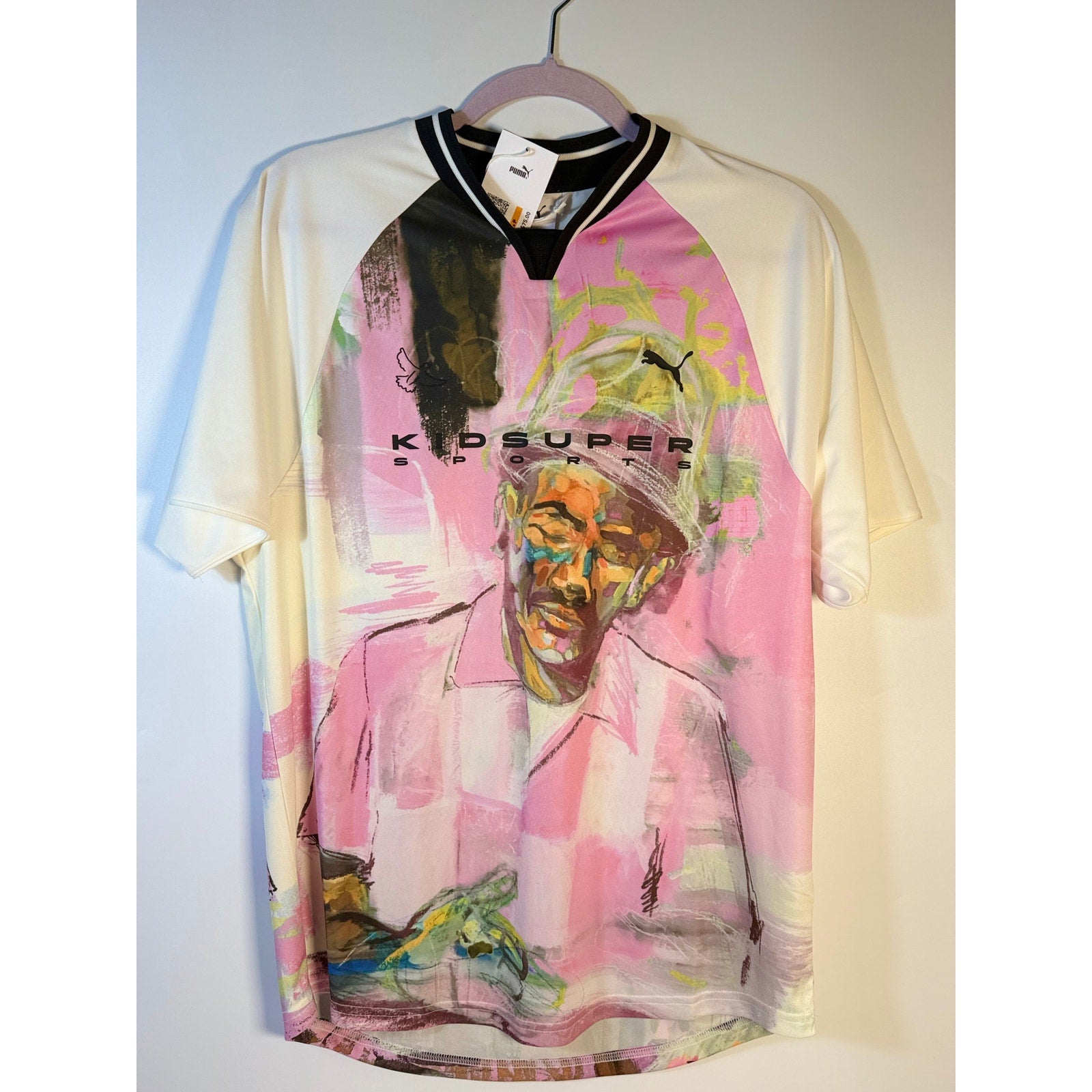 PUMA x KidSuper soccer jersey T-shirt in warm white with graphic design, men's size S, brand logo visible.