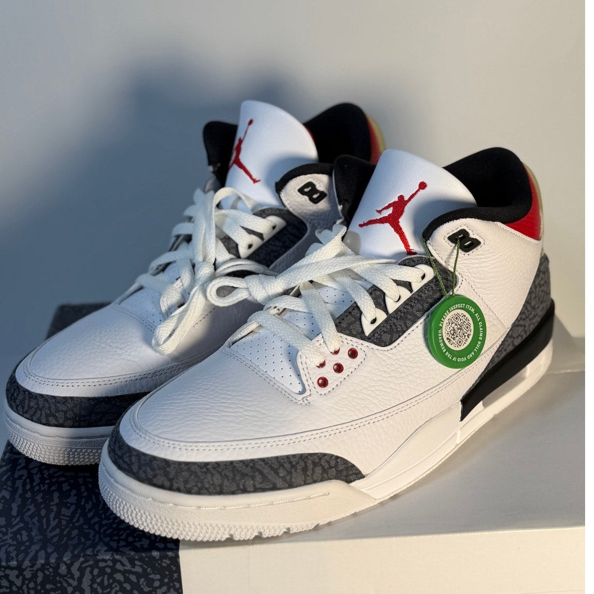 White and grey Air Jordan 3 Retro sneakers with Cement-inspired accents, featuring classic design and Jordan branding.